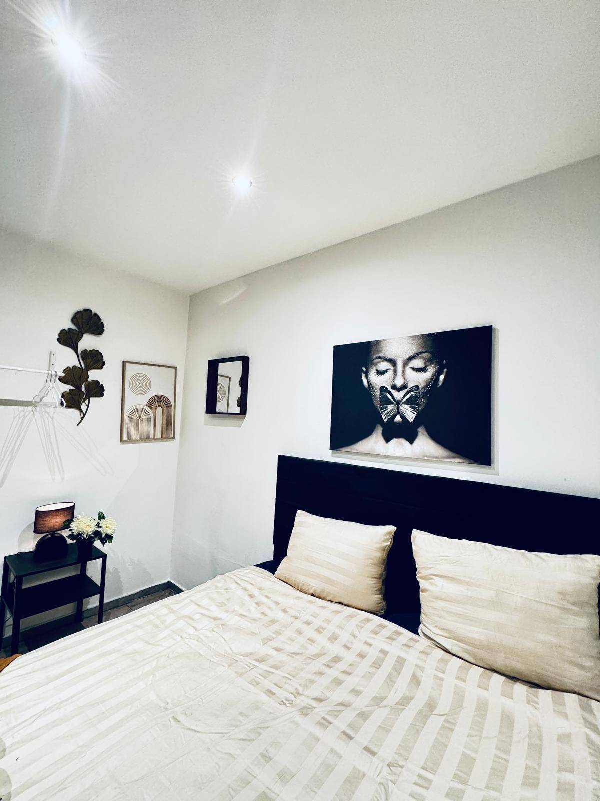 Schlafzimmer mit einem bequemen Doppelbett und stilvoller Wandkunst als Dekoration.