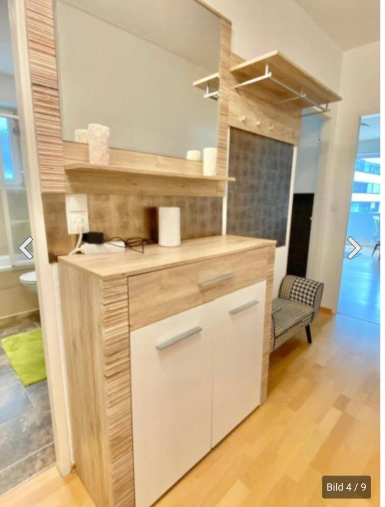 Eingangsbereich mit Spiegel, Schuhschrank und Garderobe, hell und funktional gestaltet.