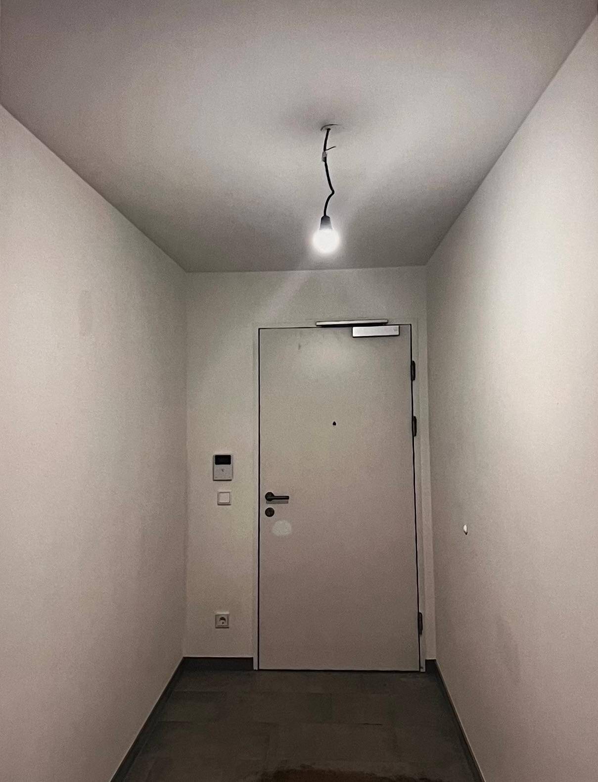 Heller Eingangsbereich mit moderner Wohnungstür und schlichtem Design.