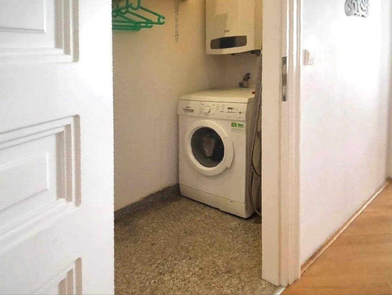 Kleiner Hauswirtschaftsraum mit Waschmaschine und Warmwasserbereiter.