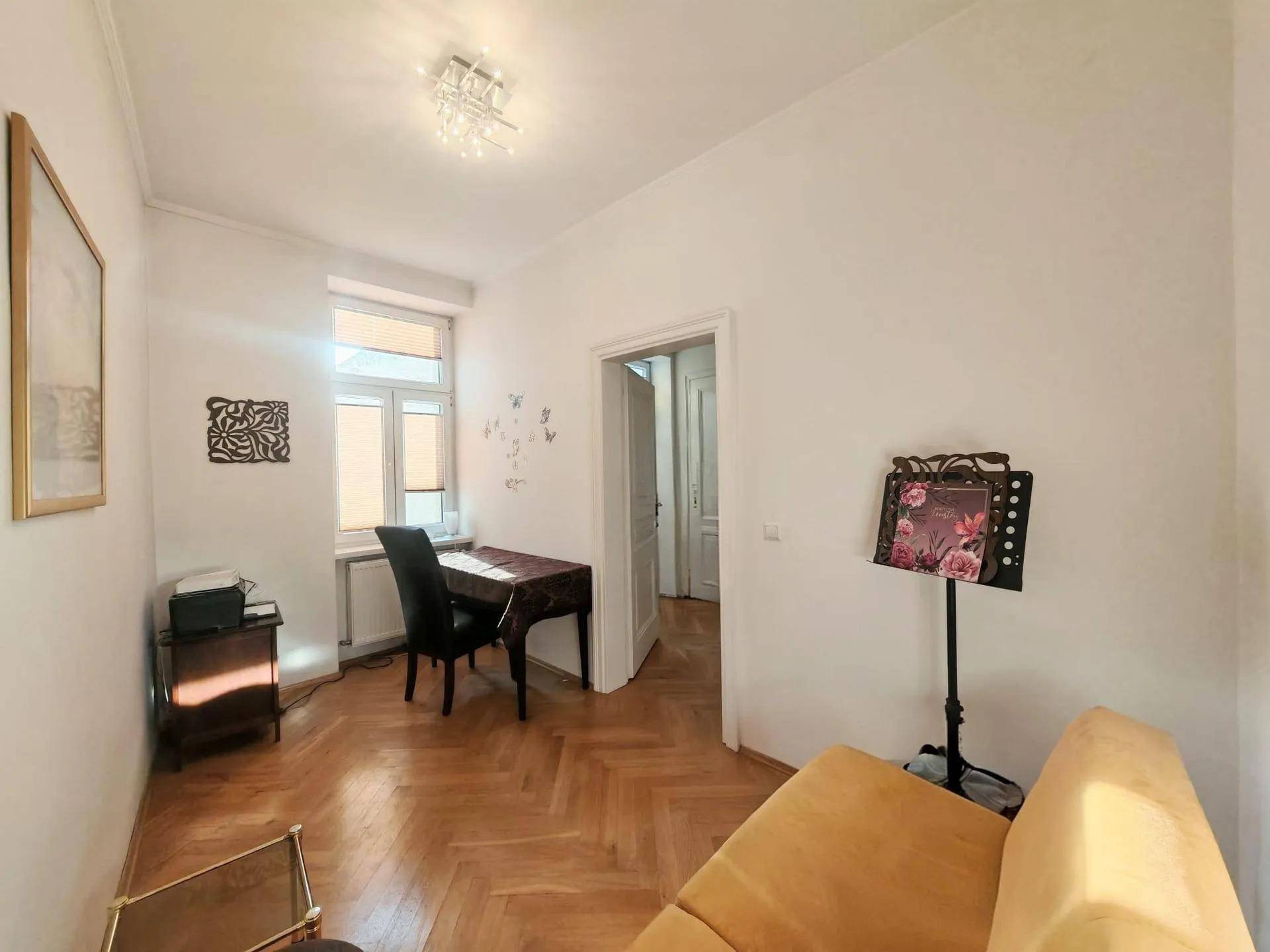 Kleines Arbeitszimmer mit Fischgrätparkett, Schreibtisch und Fenster für natürliches Licht.