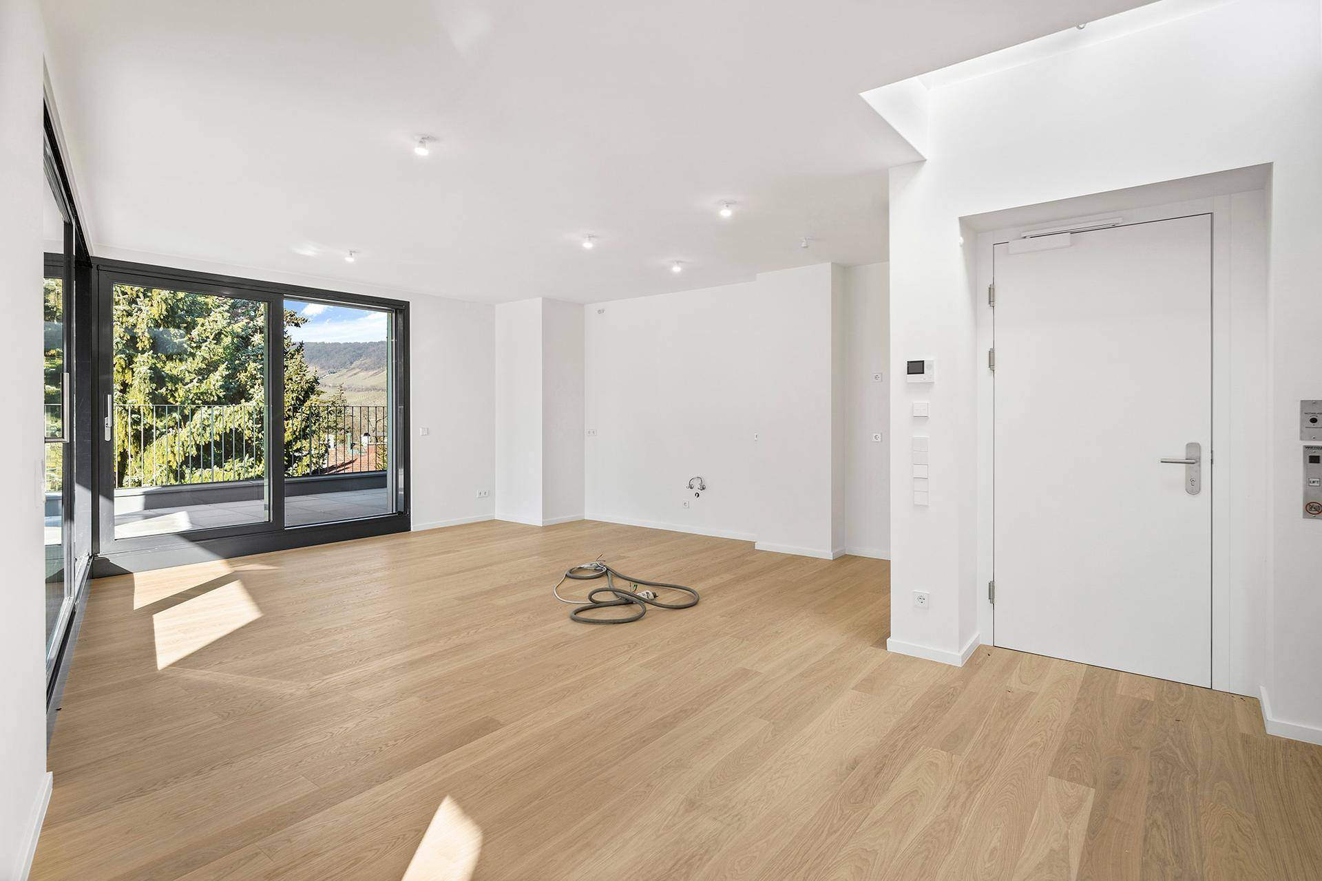Geräumiges, helles Wohnzimmer mit Eichenparkett und großen Schiebetüren zur Terrasse.