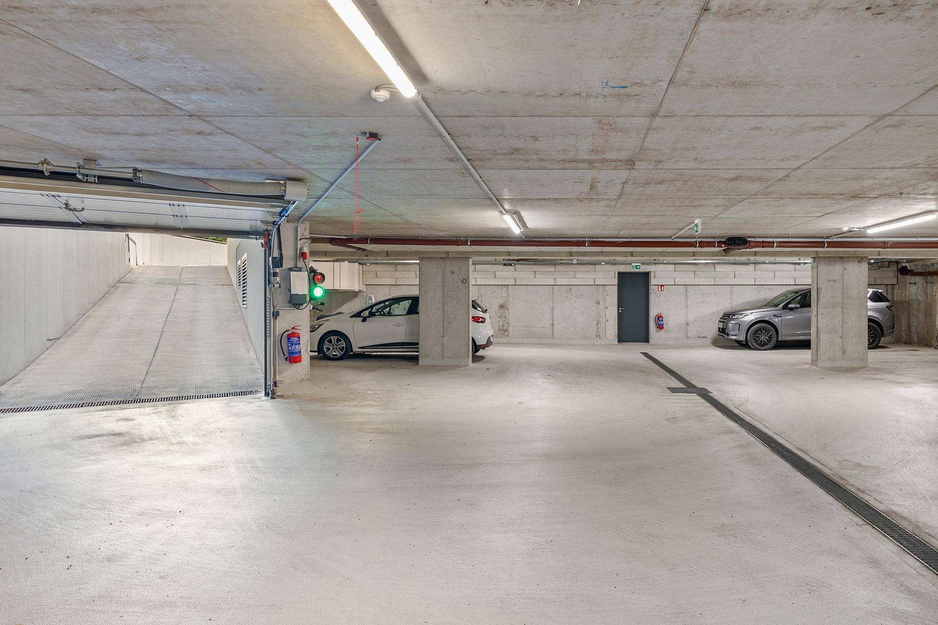 Geräumige Tiefgarage mit Betonwänden und -decken, bietet sichere Stellplätze für Fahrzeuge.