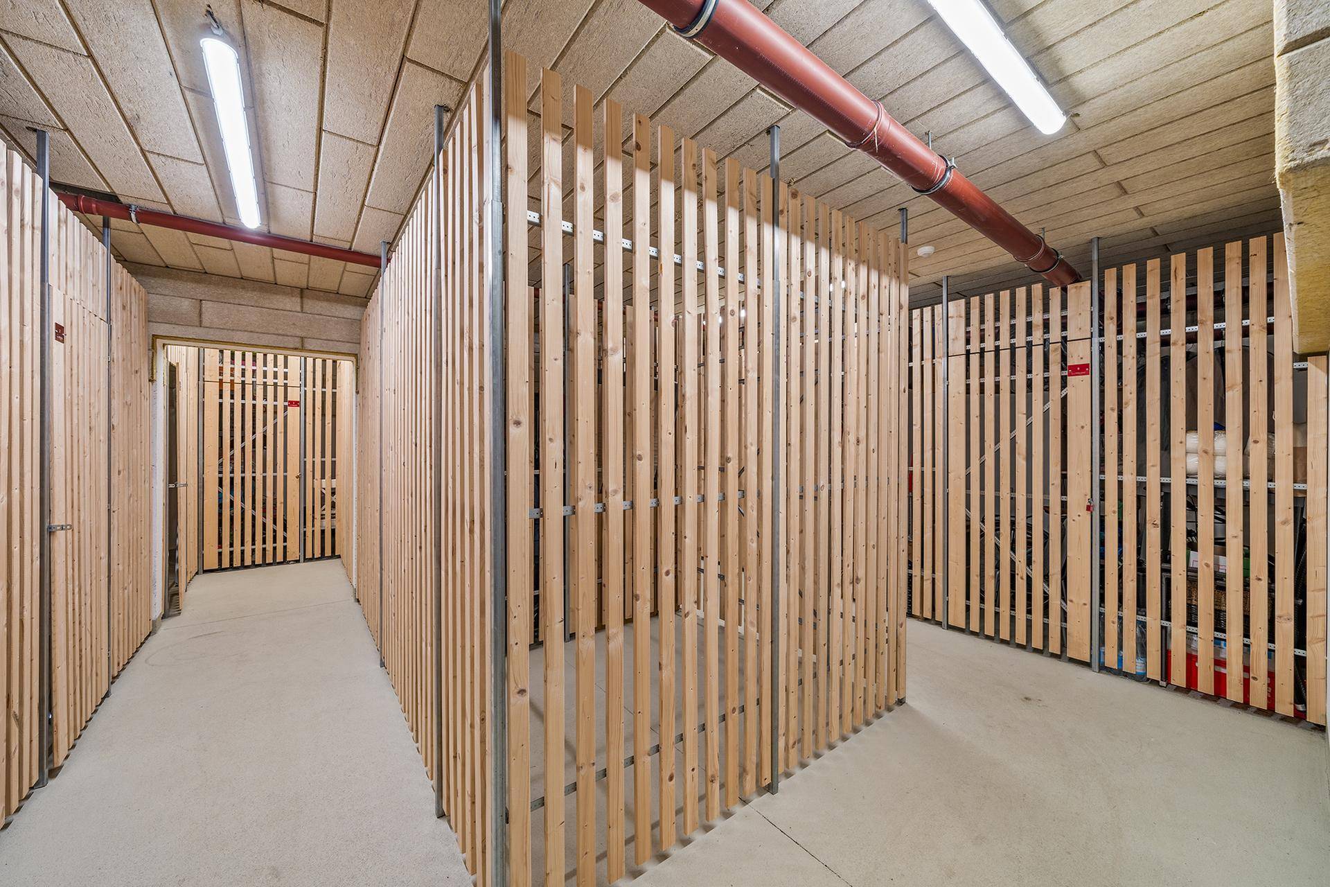Kellerabteile mit Holzlattenwänden bieten praktischen Stauraum für Bewohner.