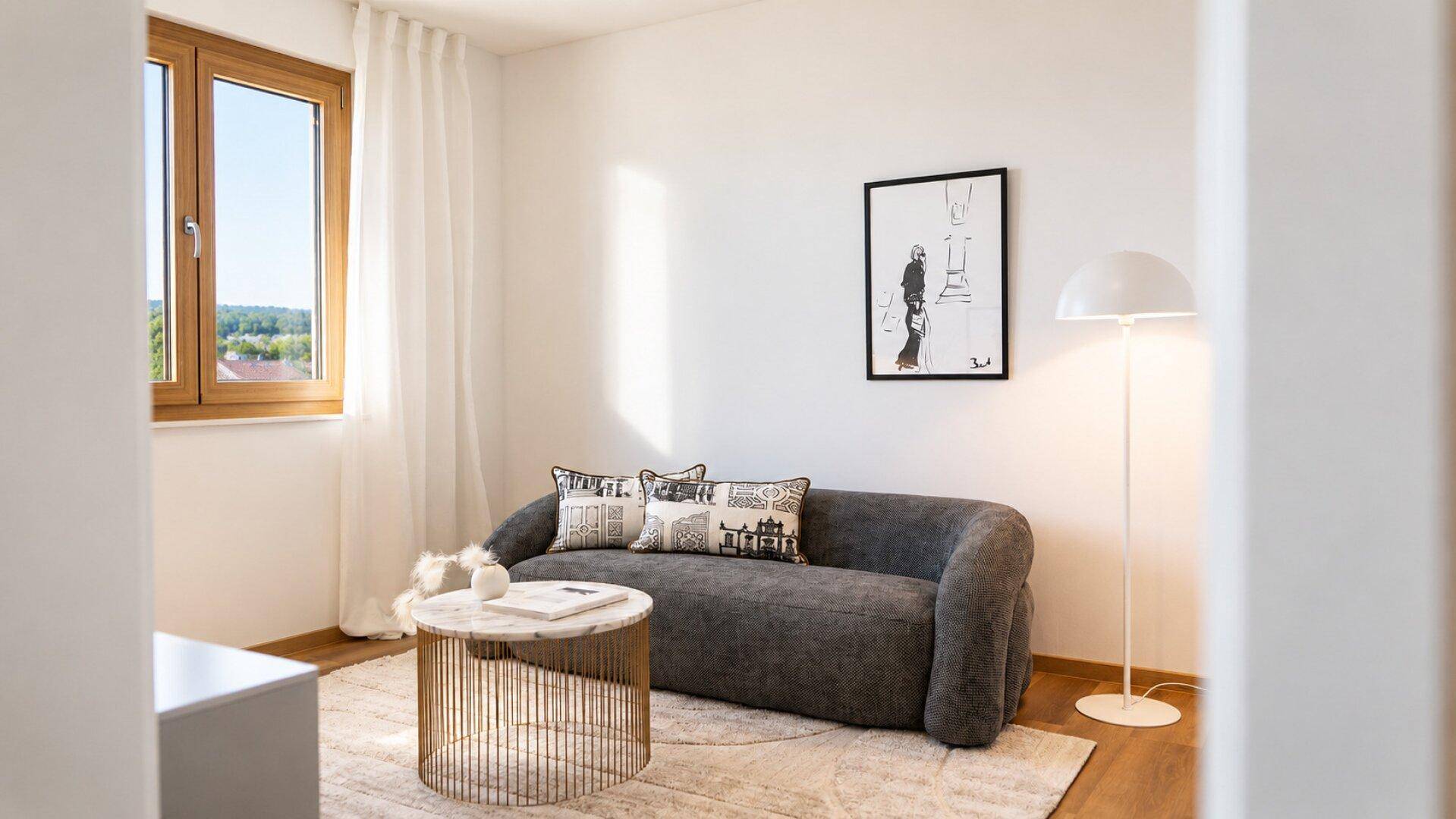Helles Wohnzimmer mit modernem Sofa, Teppich und großem Fenster, minimalistisch eingerichtet.