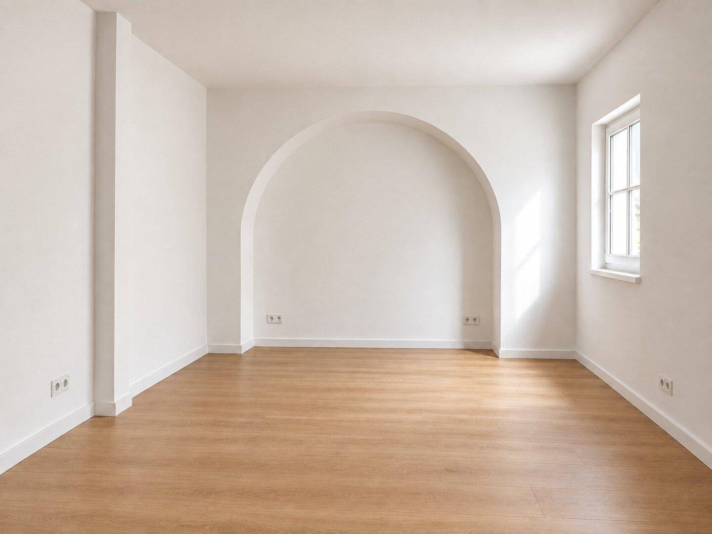 Leeres Zimmer mit hellem Holzboden, weiß gestrichenen Wänden und einem dekorativen Rundbogen.