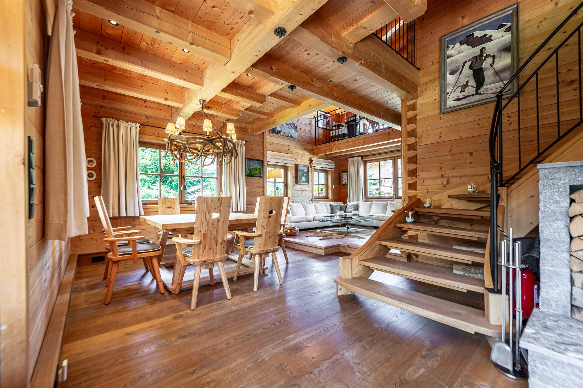 Offener Wohn-Essbereich mit Holzbalkendecke, Esstisch und Treppe zur oberen Etage.