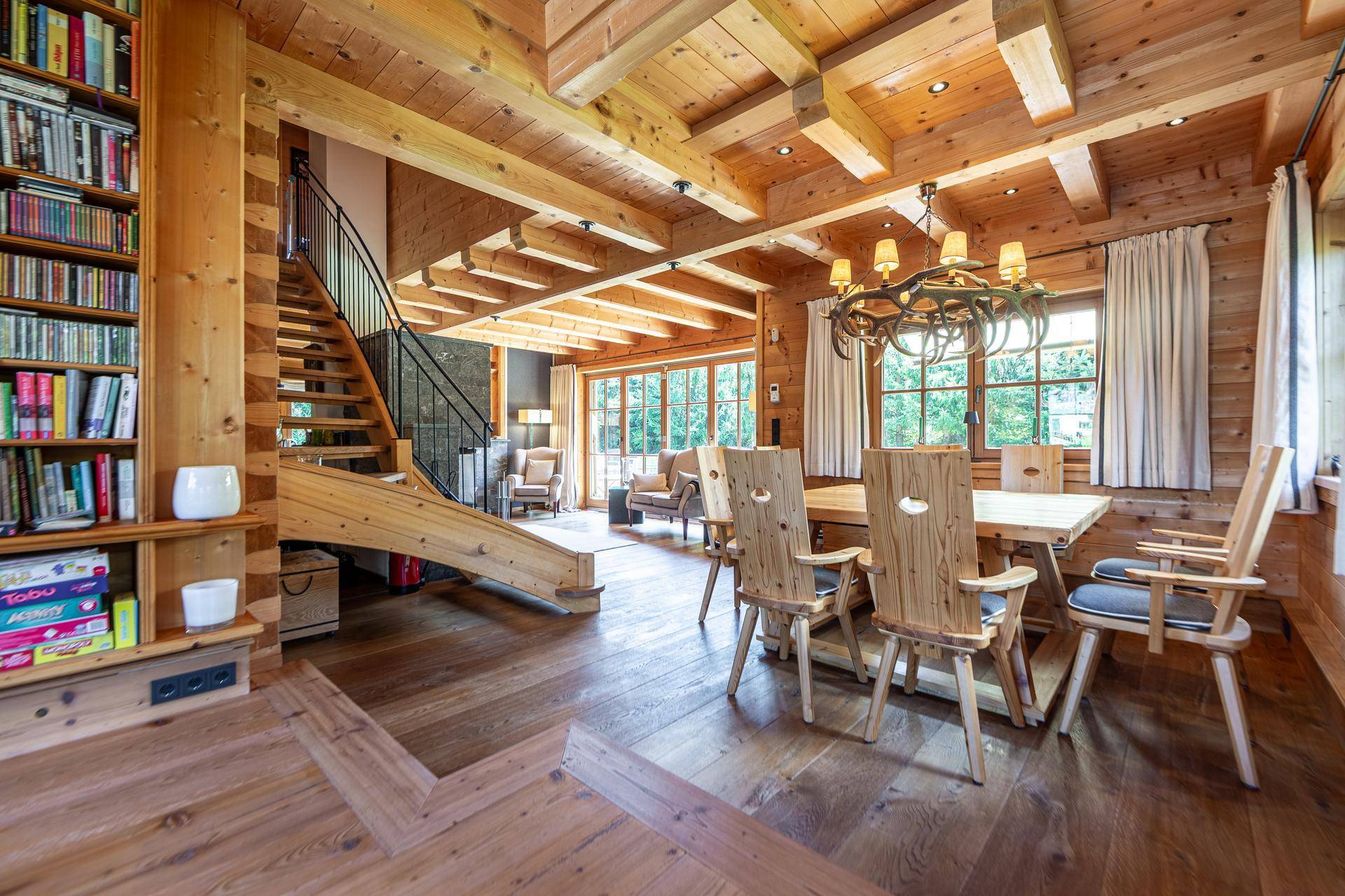 Geräumiger Wohn-Essbereich mit Holzboden, Esstisch und Treppe, die zum oberen Stockwerk führt.