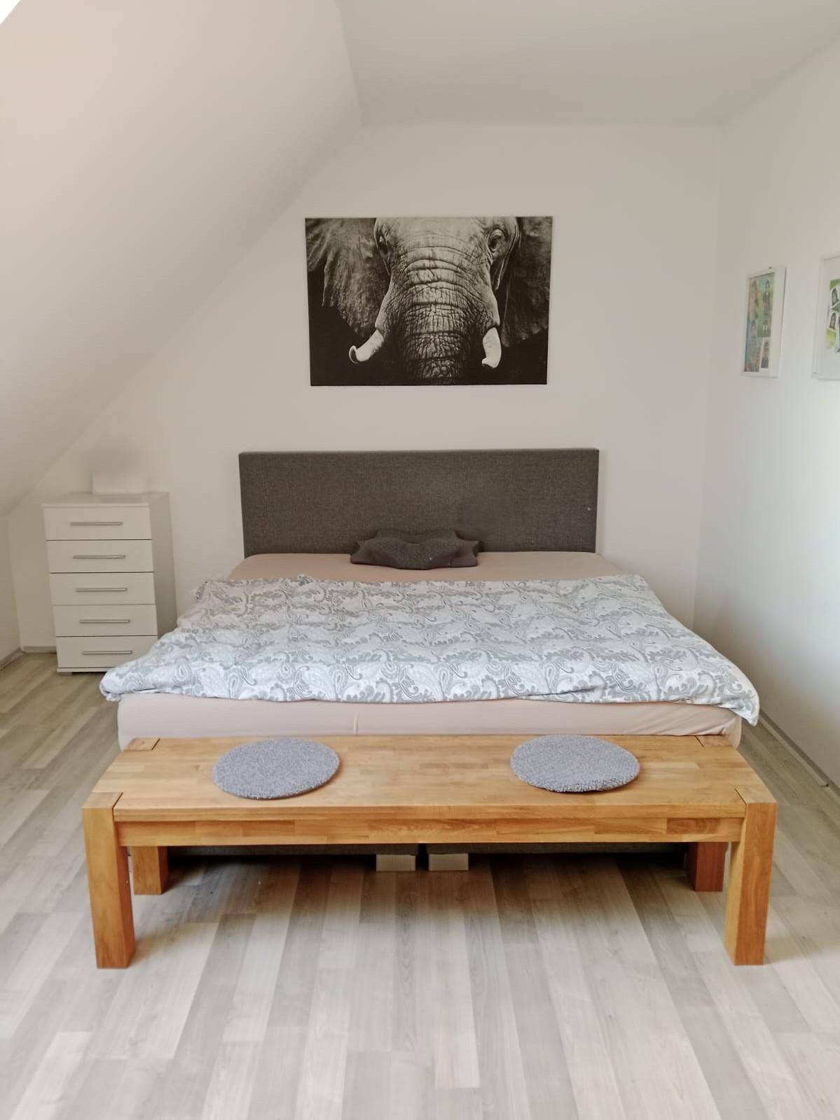 Geräumiges Schlafzimmer im Dachgeschoss mit großem Bett und Dachschrägen.