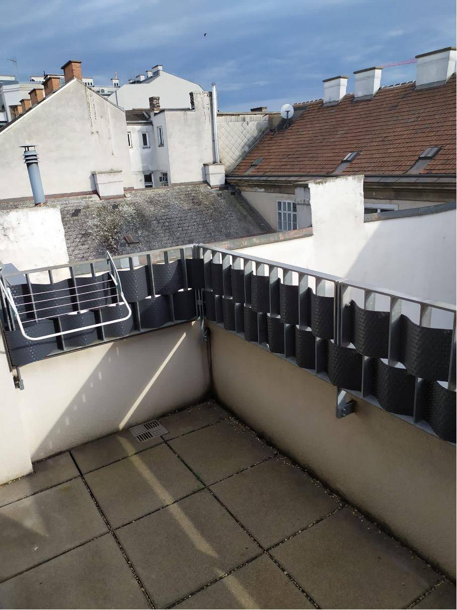 Geräumige Dachterrasse mit Blick über die umliegenden Dächer und den Himmel.