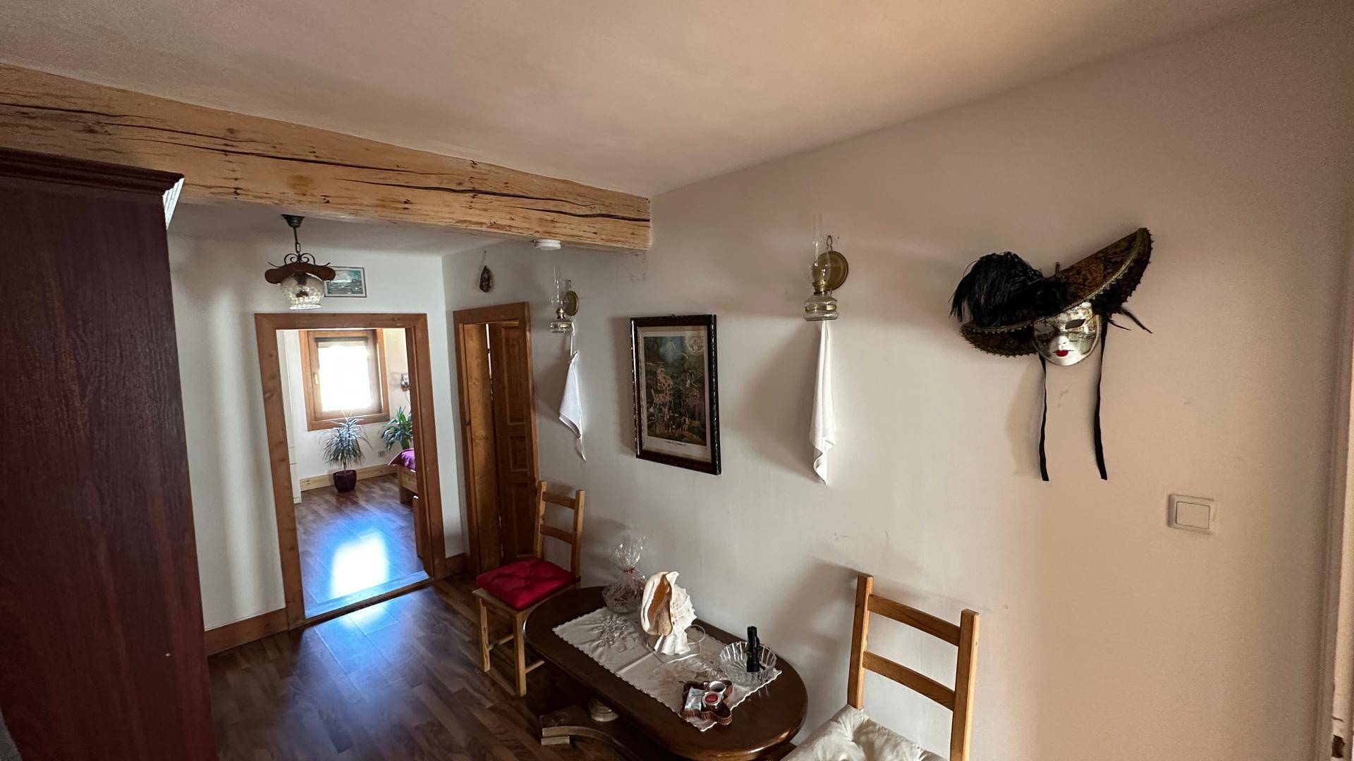 Flur mit Holzboden, dekorativen Elementen und Blick in den angrenzenden Raum.