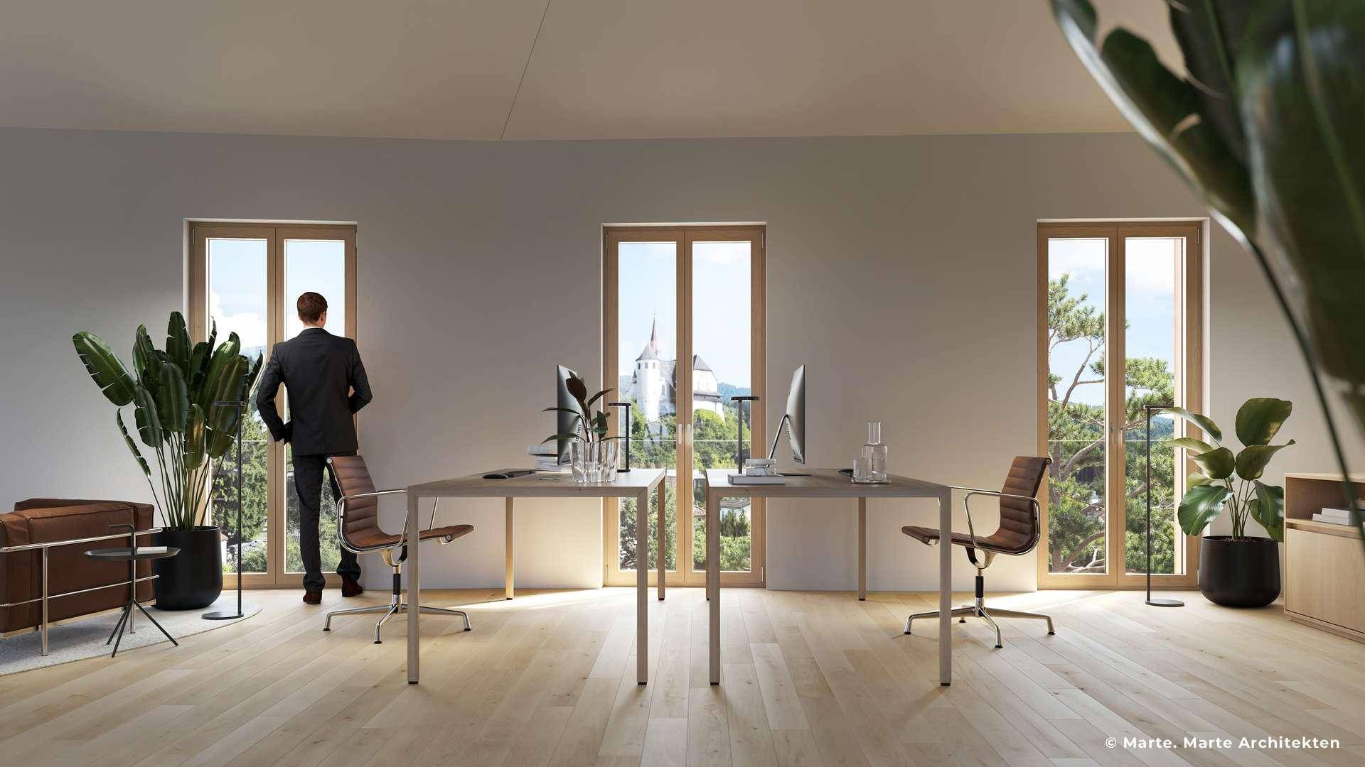Helles, modernes Büro mit großen Fenstern, Holzboden und Blick auf eine historische Kirche in der Ferne.