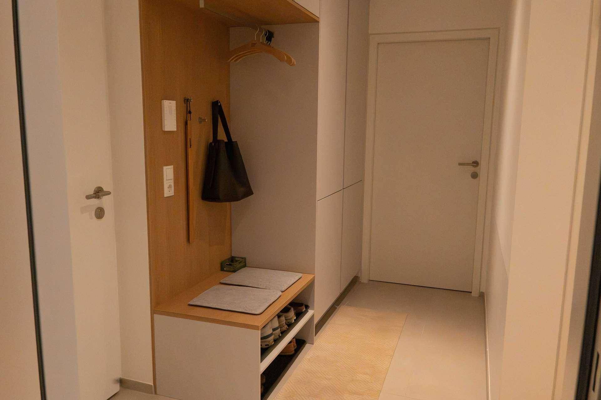 Heller Eingangsbereich mit integrierter Garderobe und Schuhablage.