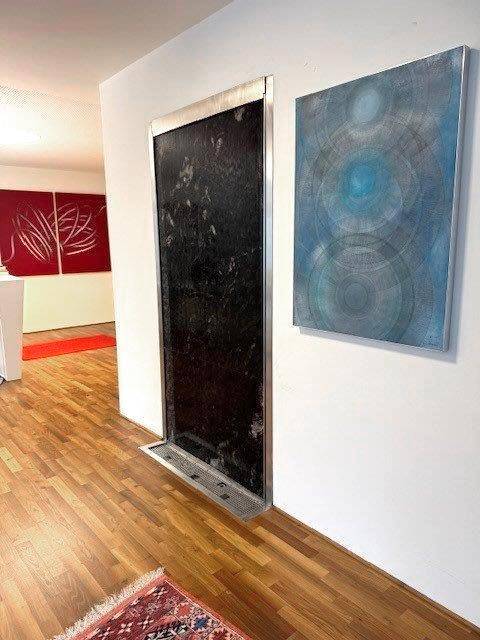 Flur mit Holzboden, moderner Kunst und einem dekorativen Wandelement, das den Raum stilvoll gestaltet.