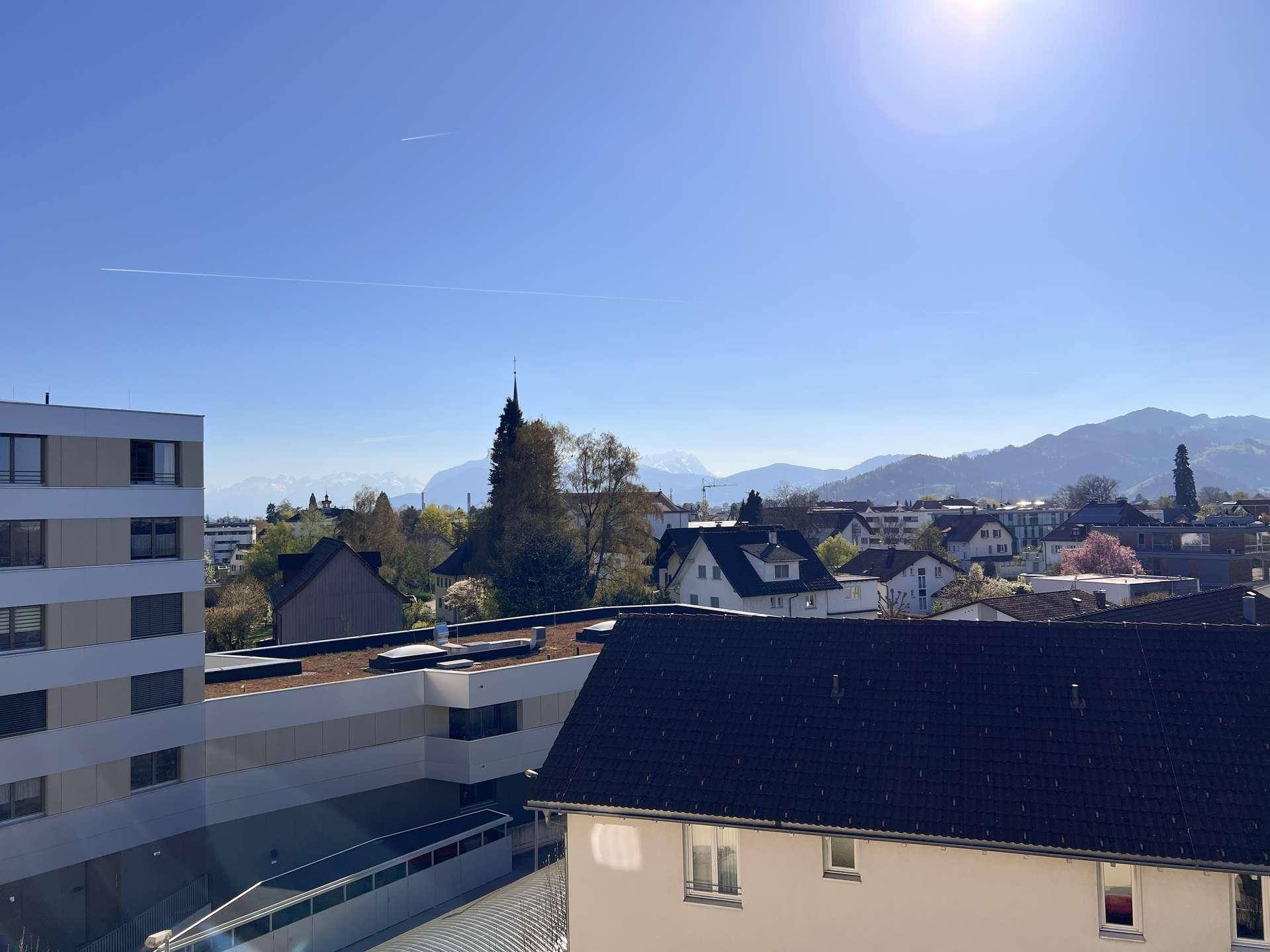 Weitläufiger Blick über die Stadt und die umliegende Berglandschaft an einem sonnigen Tag.