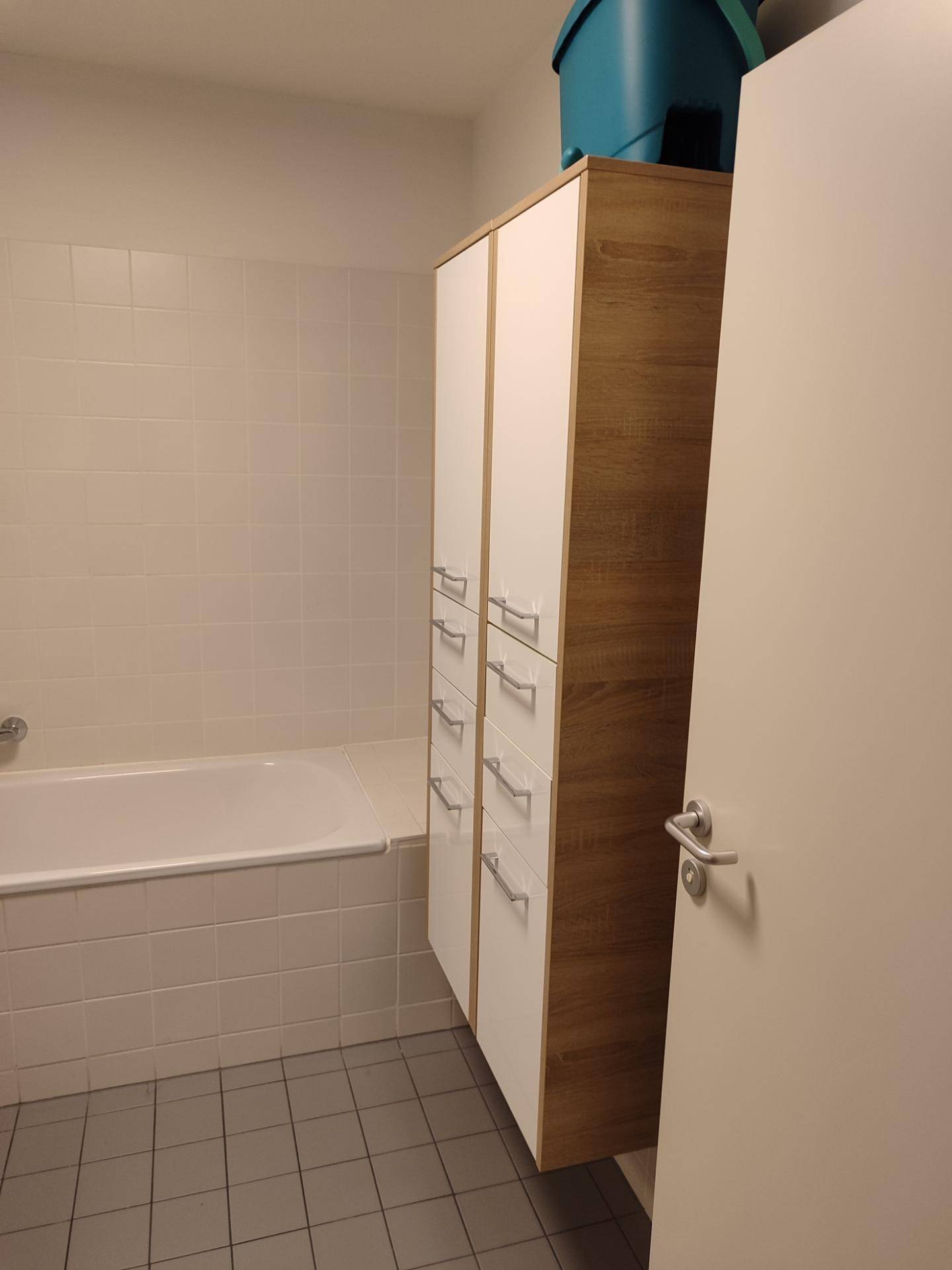 Badezimmer mit eingebauter Badewanne und weißen Fliesen an den Wänden.