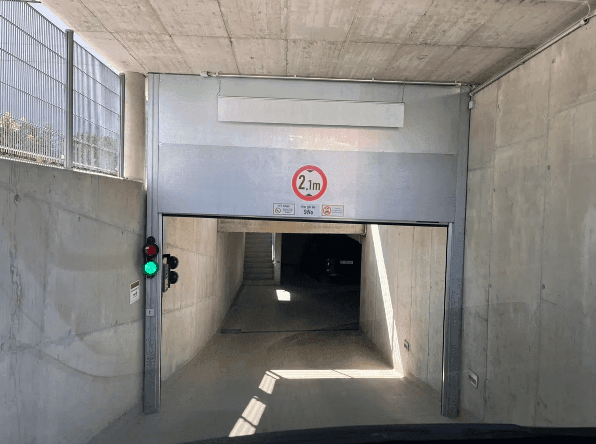 Einfahrt zur Tiefgarage mit Höhenbegrenzung von 2,1 Metern und einer Ampel zur Verkehrsregelung.