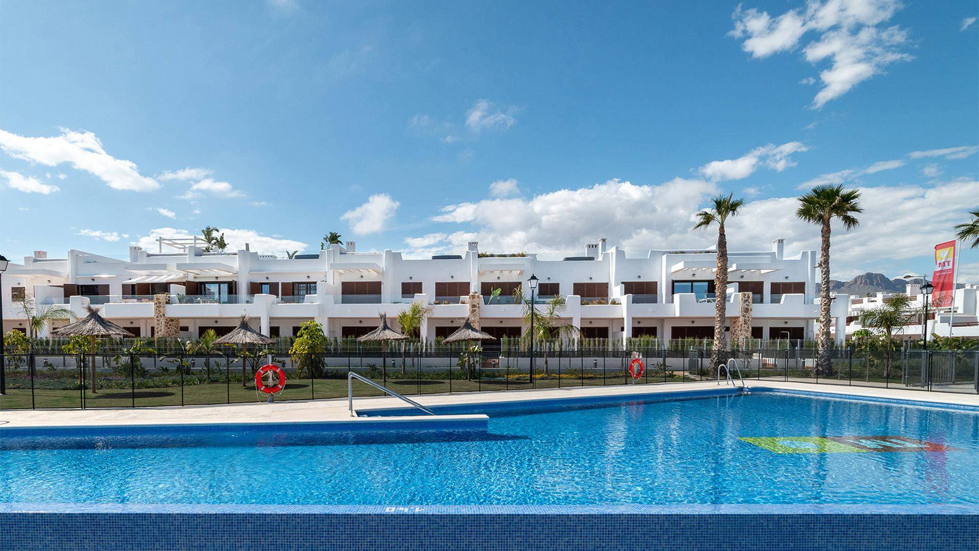 Eine moderne Wohnanlage mit einem großen Gemeinschaftspool und Reihenhäusern.
