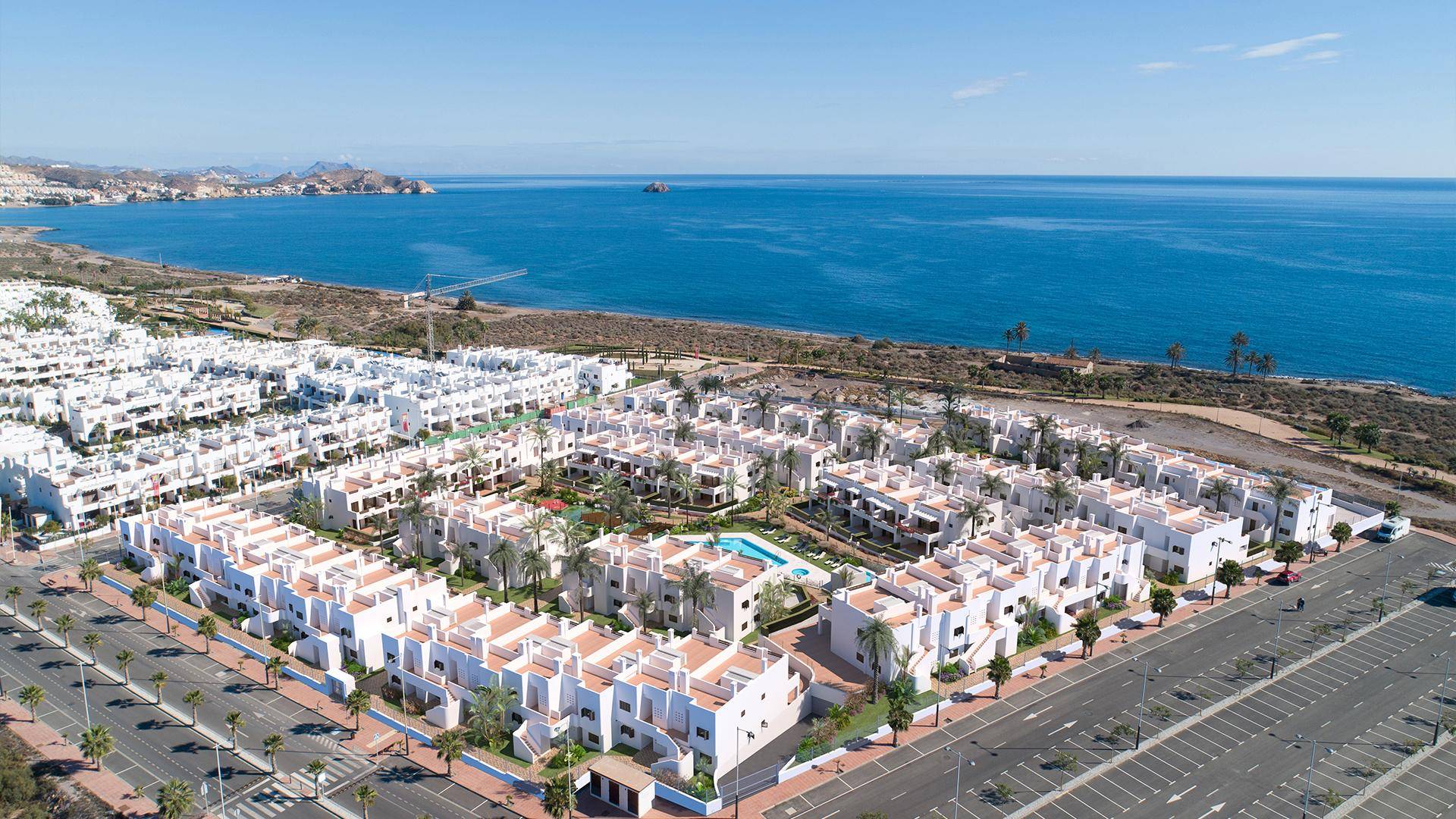 Eine weitläufige Wohnanlage am Meer mit vielen weißen Häusern und Pools.