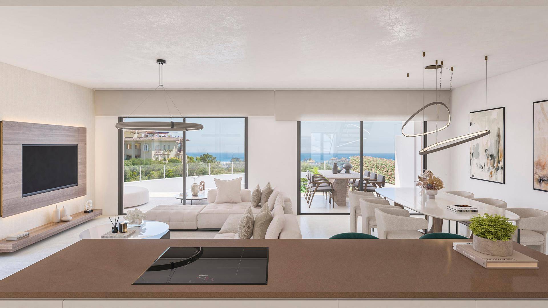 Heller offener Wohn-Essbereich mit moderner Küche, Insel und Zugang zur Terrasse mit Meerblick.