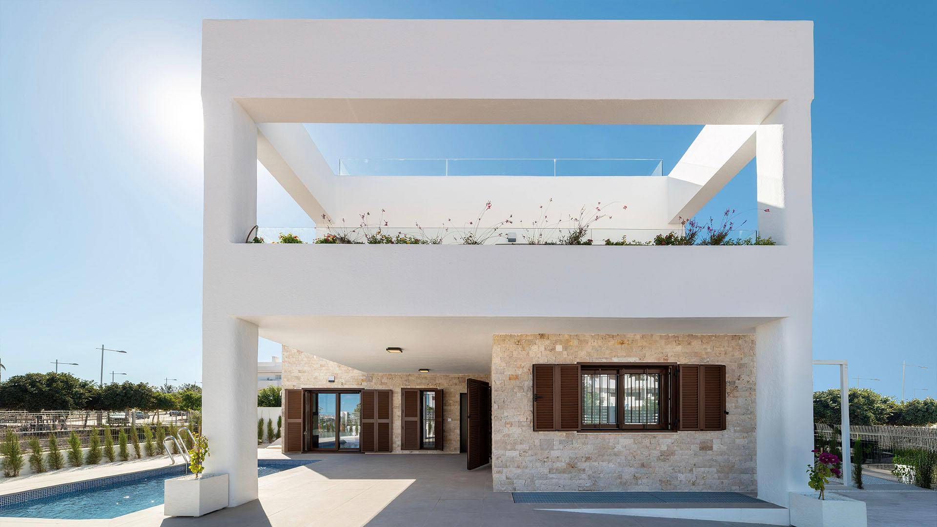 Vorderansicht einer modernen Villa mit weißer Fassade und traditionellen Fensterläden.