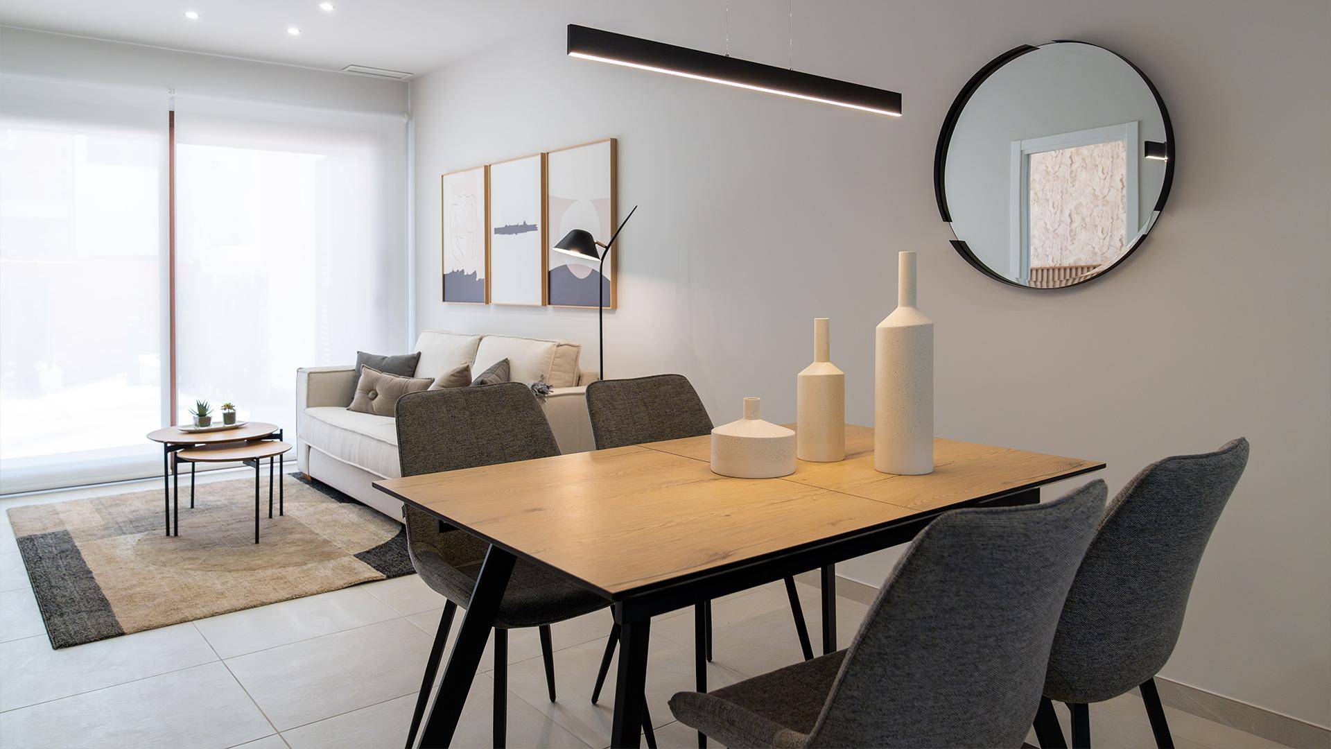 Moderner Essbereich mit Holztisch, grauen Stühlen und minimalistischer Dekoration.