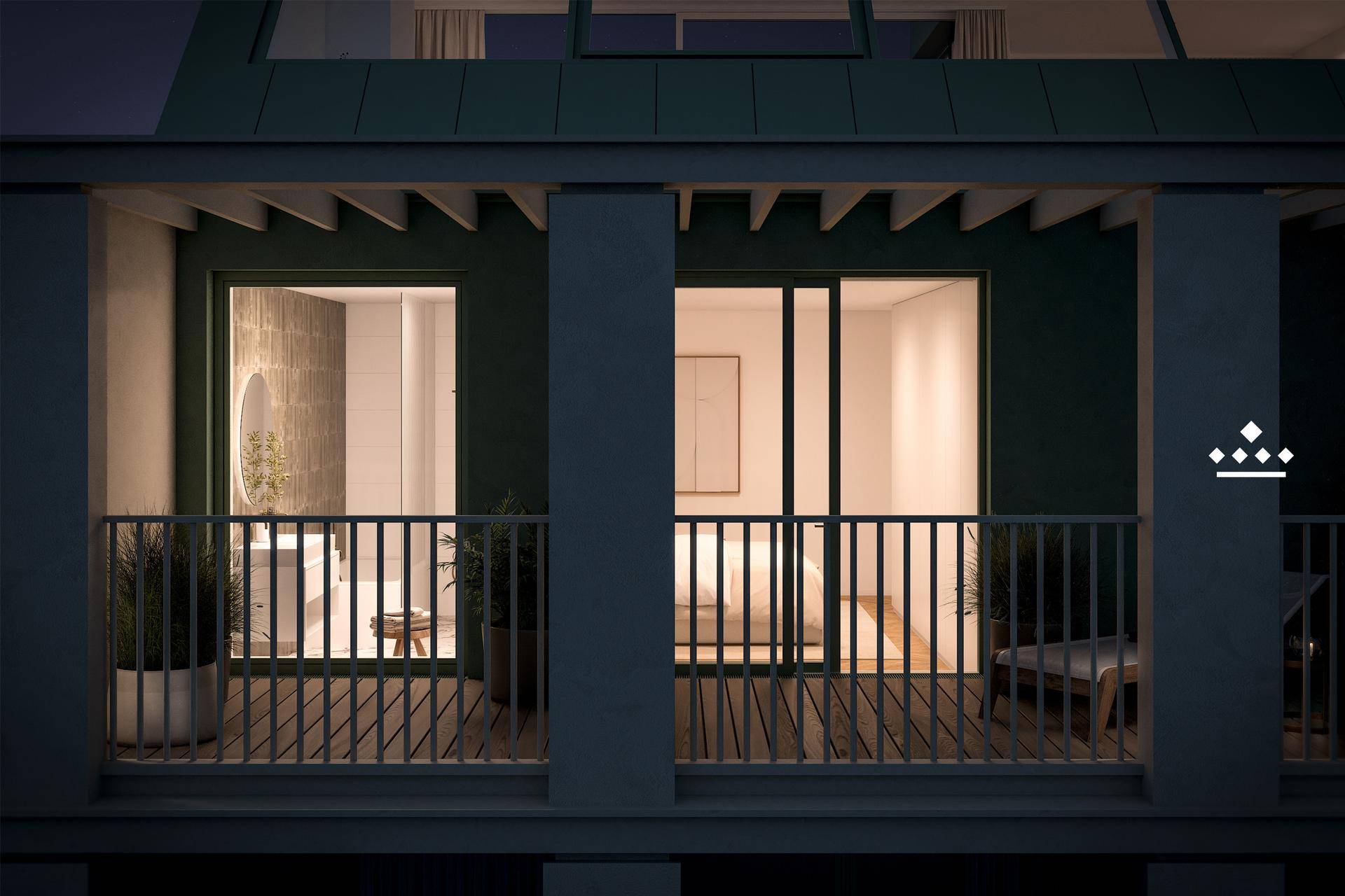 Balkon bei Nacht mit Blick auf beleuchtete Innenräume, darunter ein Badezimmer und Schlafzimmer.