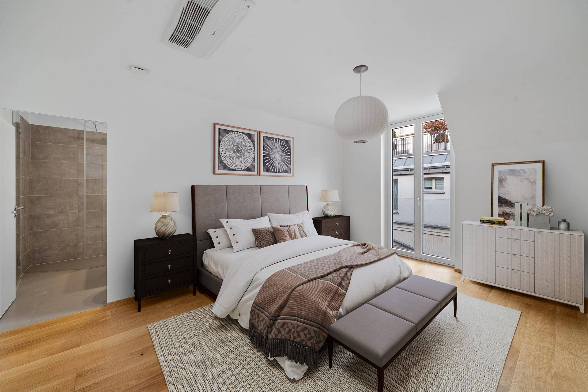 Modernes Schlafzimmer mit hellem Holzboden, großem Bett und integriertem Duschbereich.