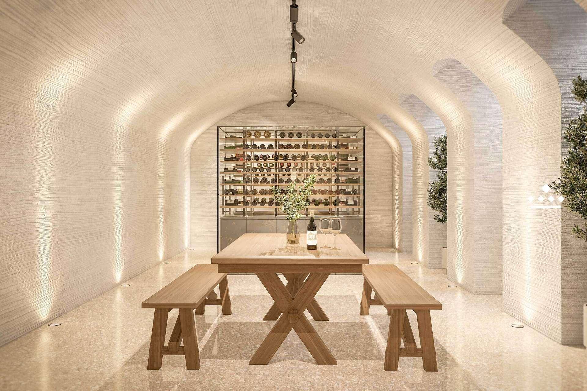 Einladender Weinkeller mit gewölbter Decke, großem Holztisch und integriertem Weinregal für gesellige Runden.