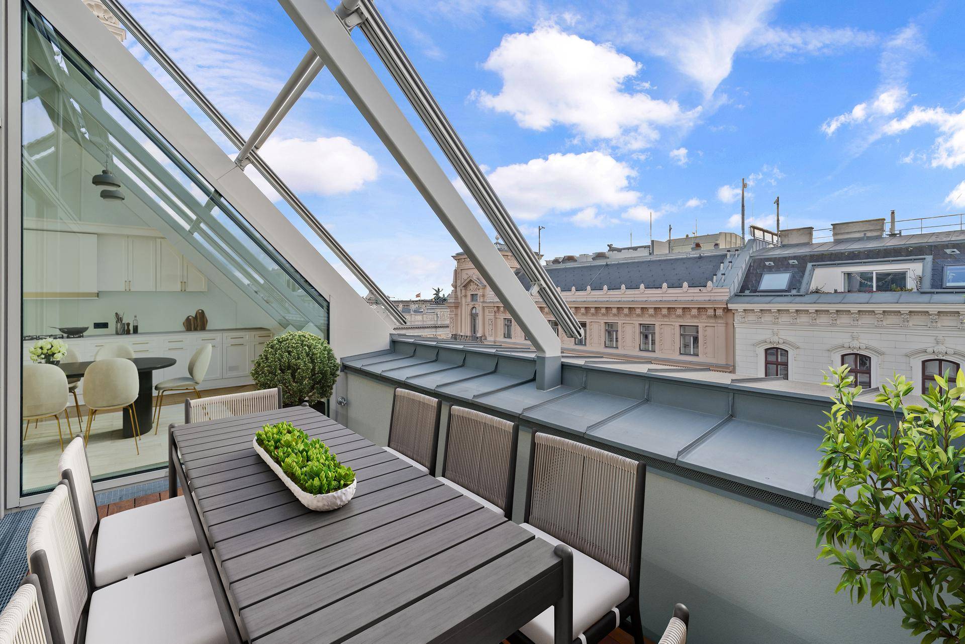 Gemütliche Terrasse mit Esstisch und Stühlen, angrenzend an den Wohnbereich mit Stadtblick.