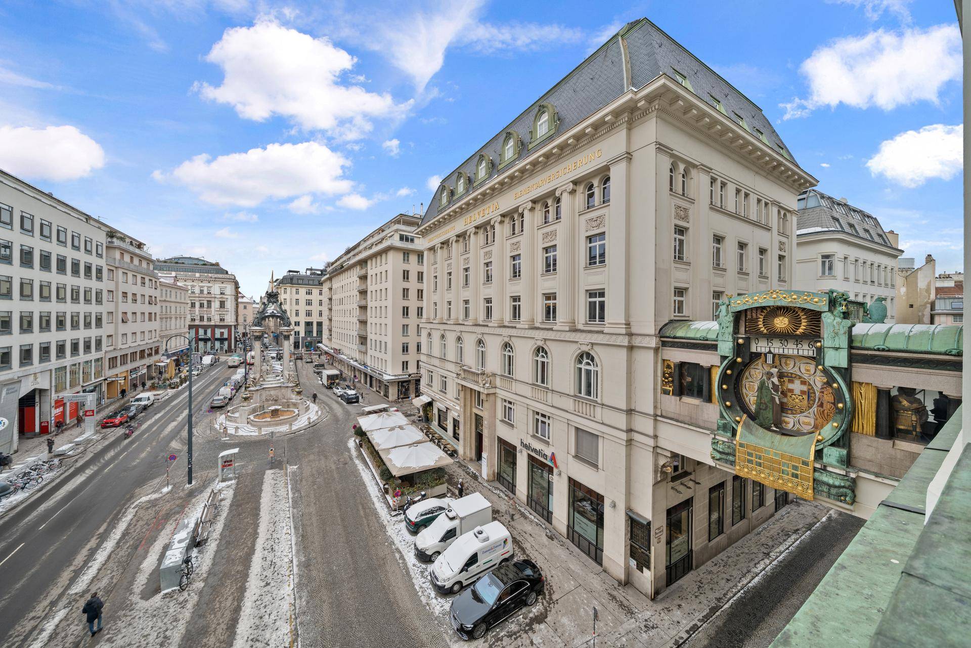 Panoramablick auf das historische Gebäude mit markanter Uhr und die umliegende Stadtlandschaft im Schnee.