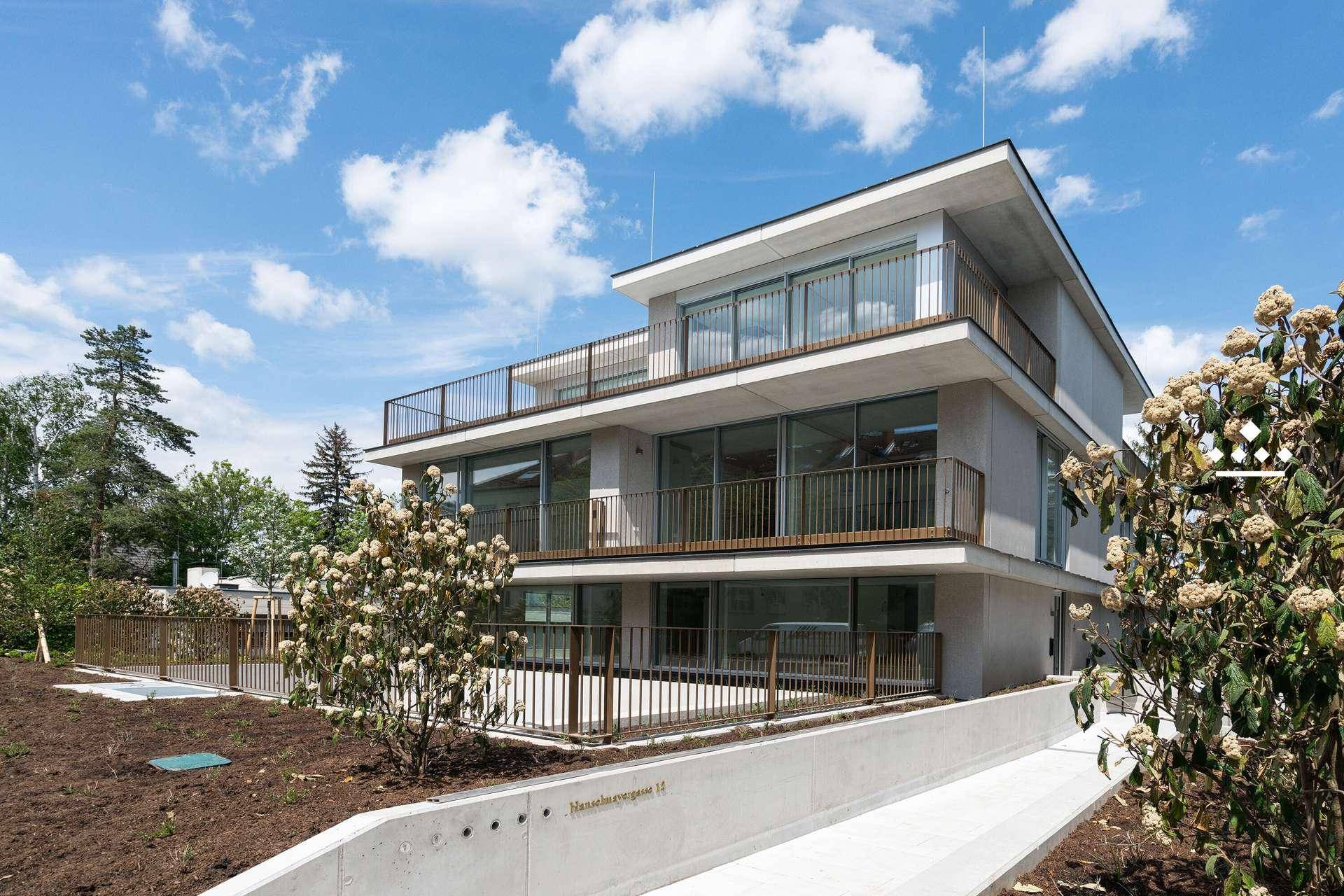 Moderne Wohnanlage mit barrierefreiem Zugang über eine Rampe und gepflegter Außenanlage.