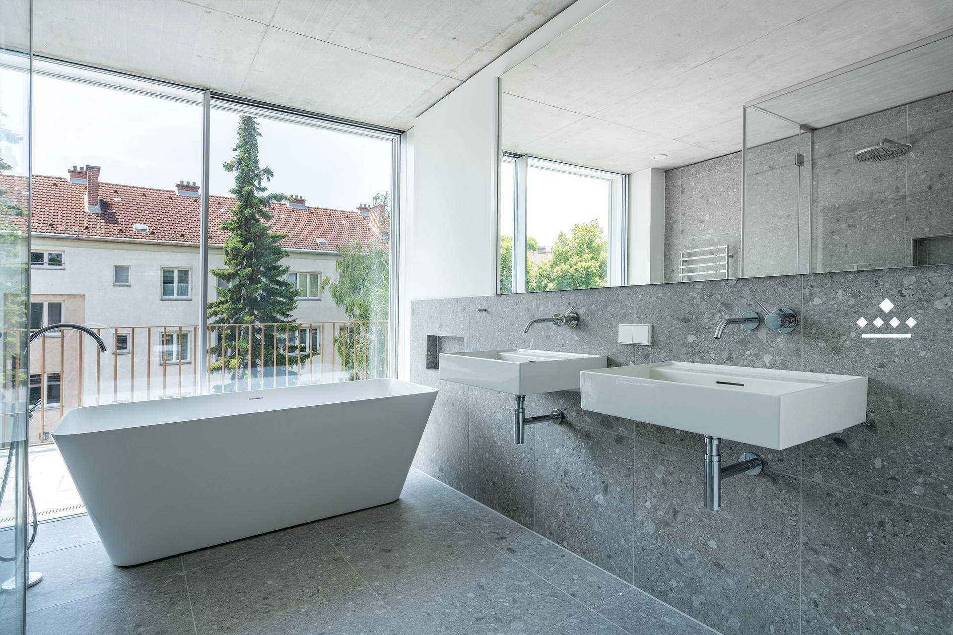 Elegantes Badezimmer mit Doppelwaschbecken, freistehender Badewanne und großen Fenstern.