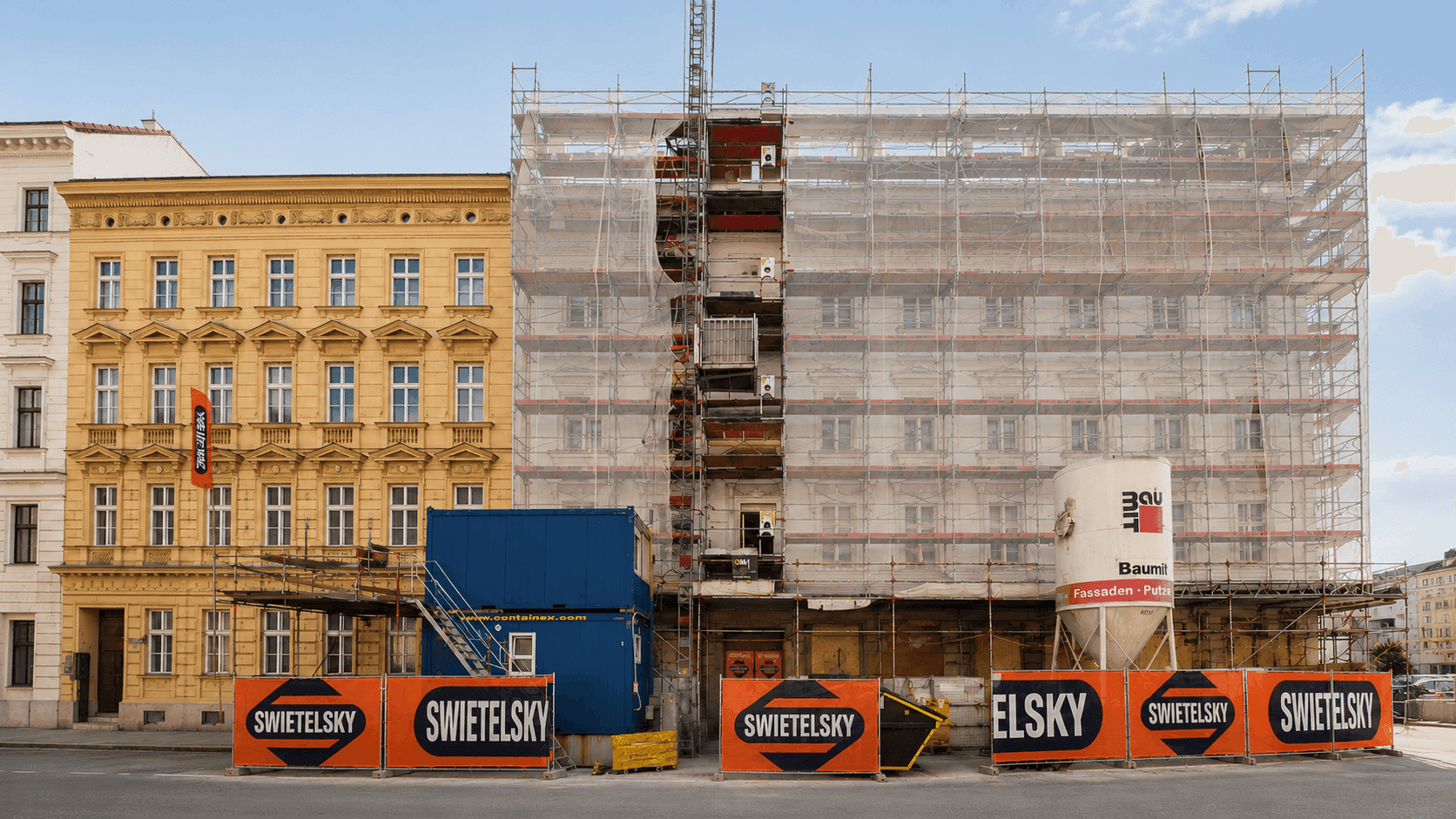 Baustelle eines Gebäudes mit Gerüst und Containern in urbaner Umgebung.