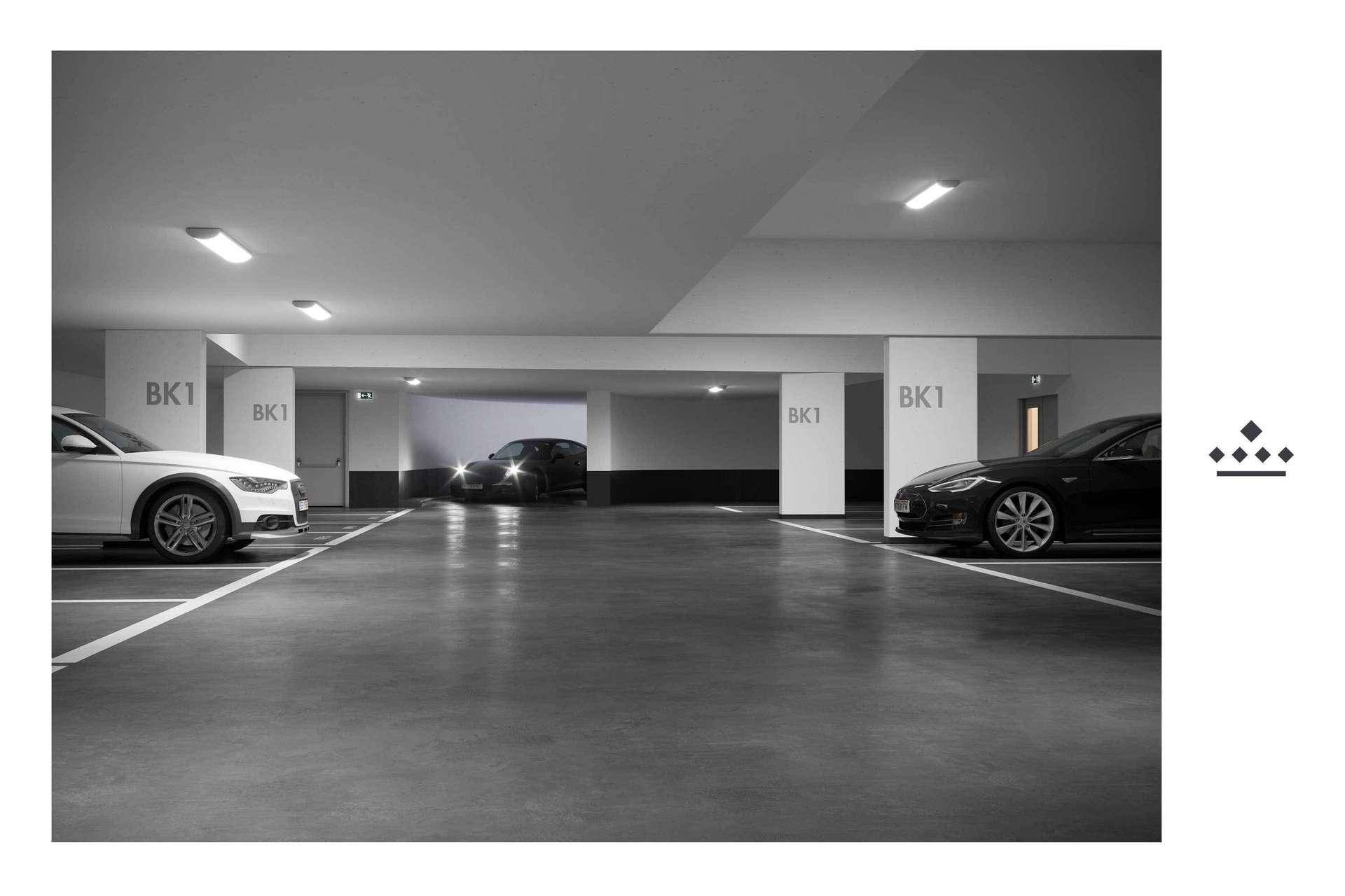 Tiefgarage mit mehreren Stellplätzen und modernen Fahrzeugen.