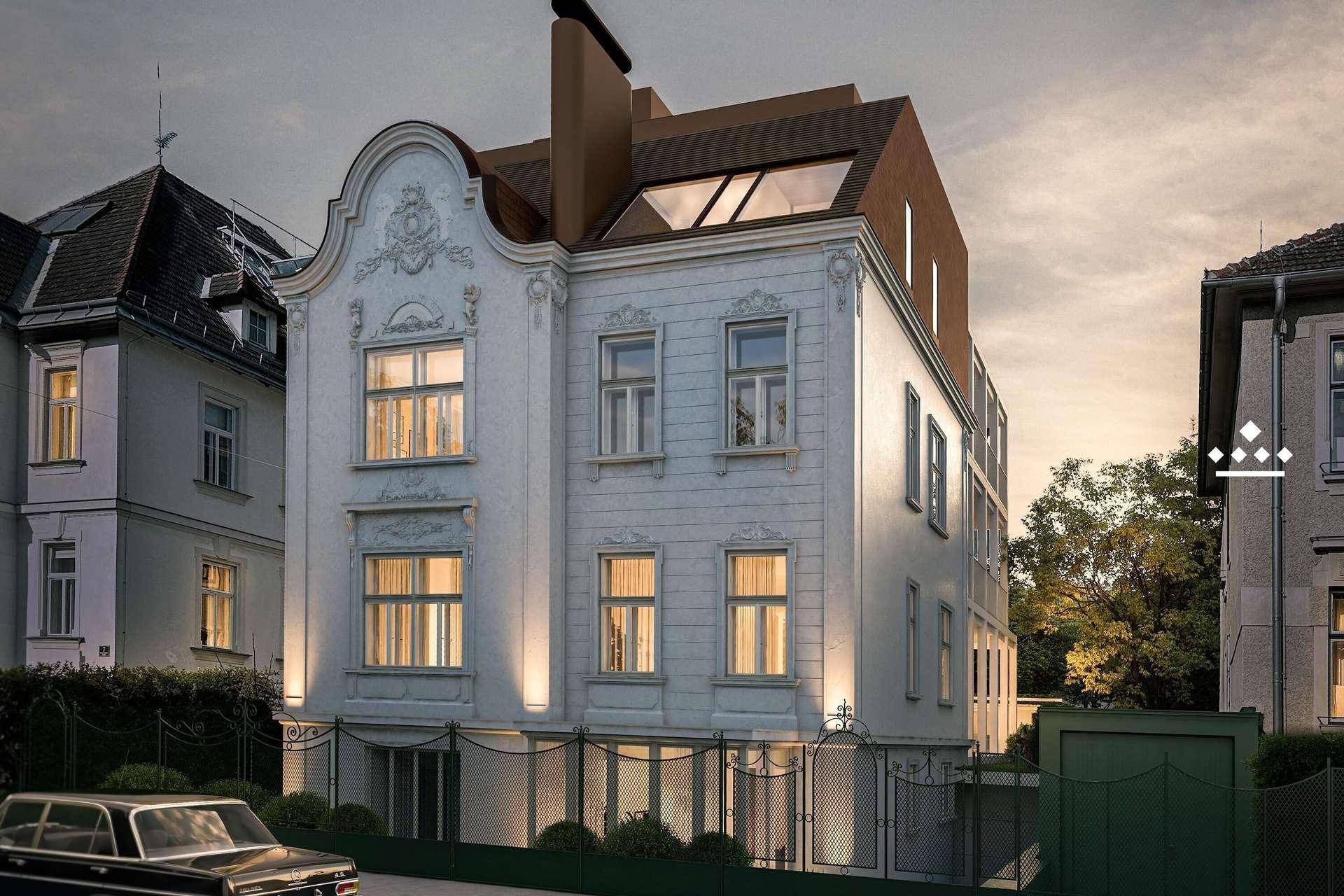 Historisches Gebäude mit beleuchteter Fassade und moderner Dachaufstockung in der Abenddämmerung.