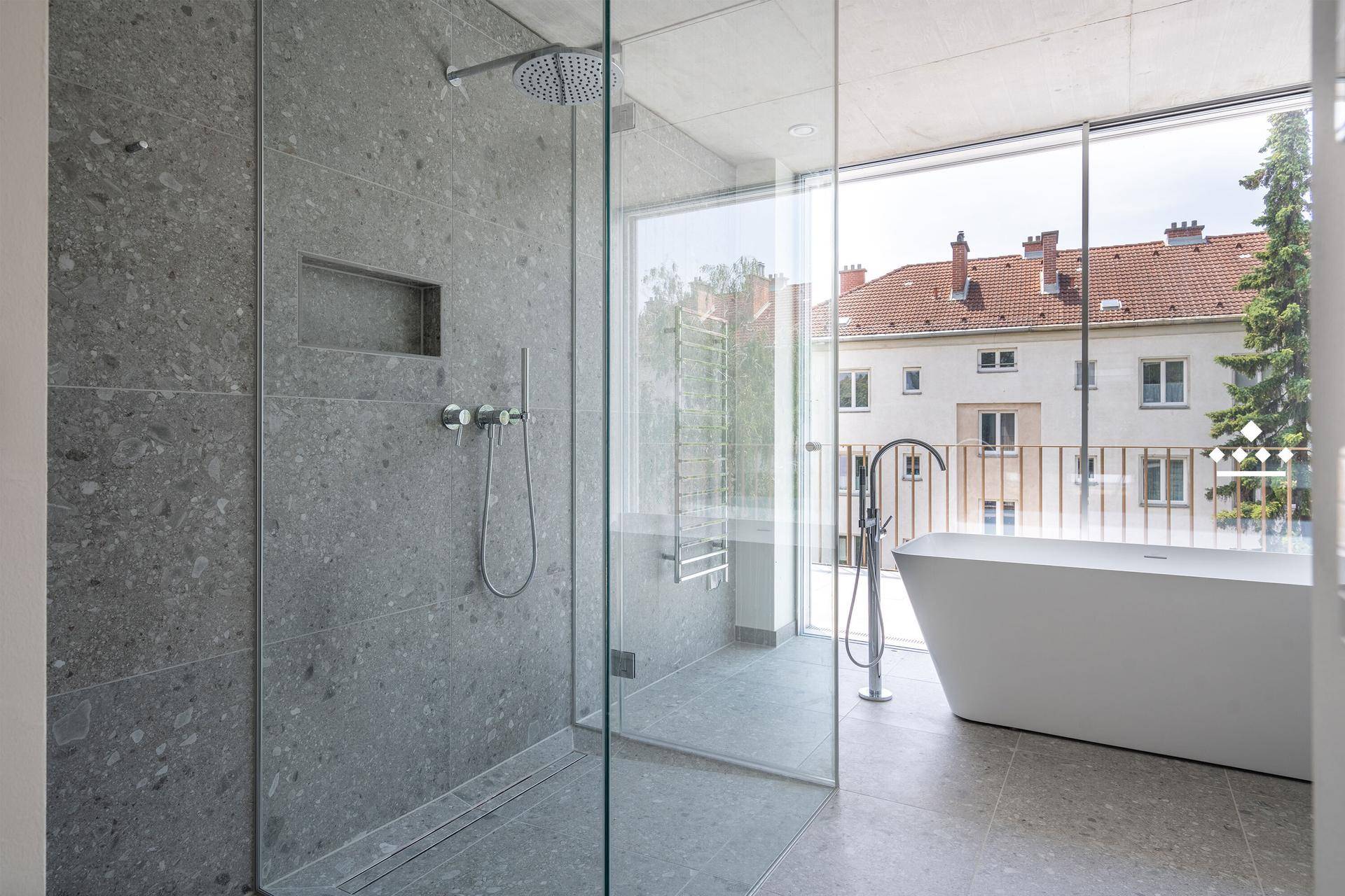 Modernes Badezimmer mit großer begehbarer Dusche, freistehender Badewanne und Fensterblick.