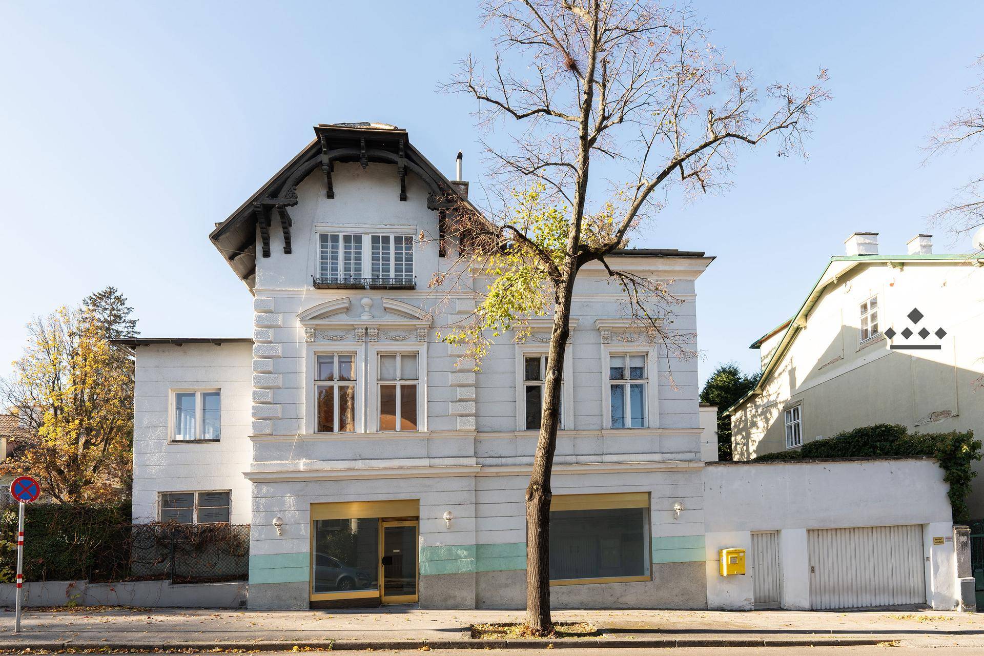 Straßenansicht des Altbaus mit Ladenflächen im Erdgeschoss und klassischer Fassadengestaltung.
