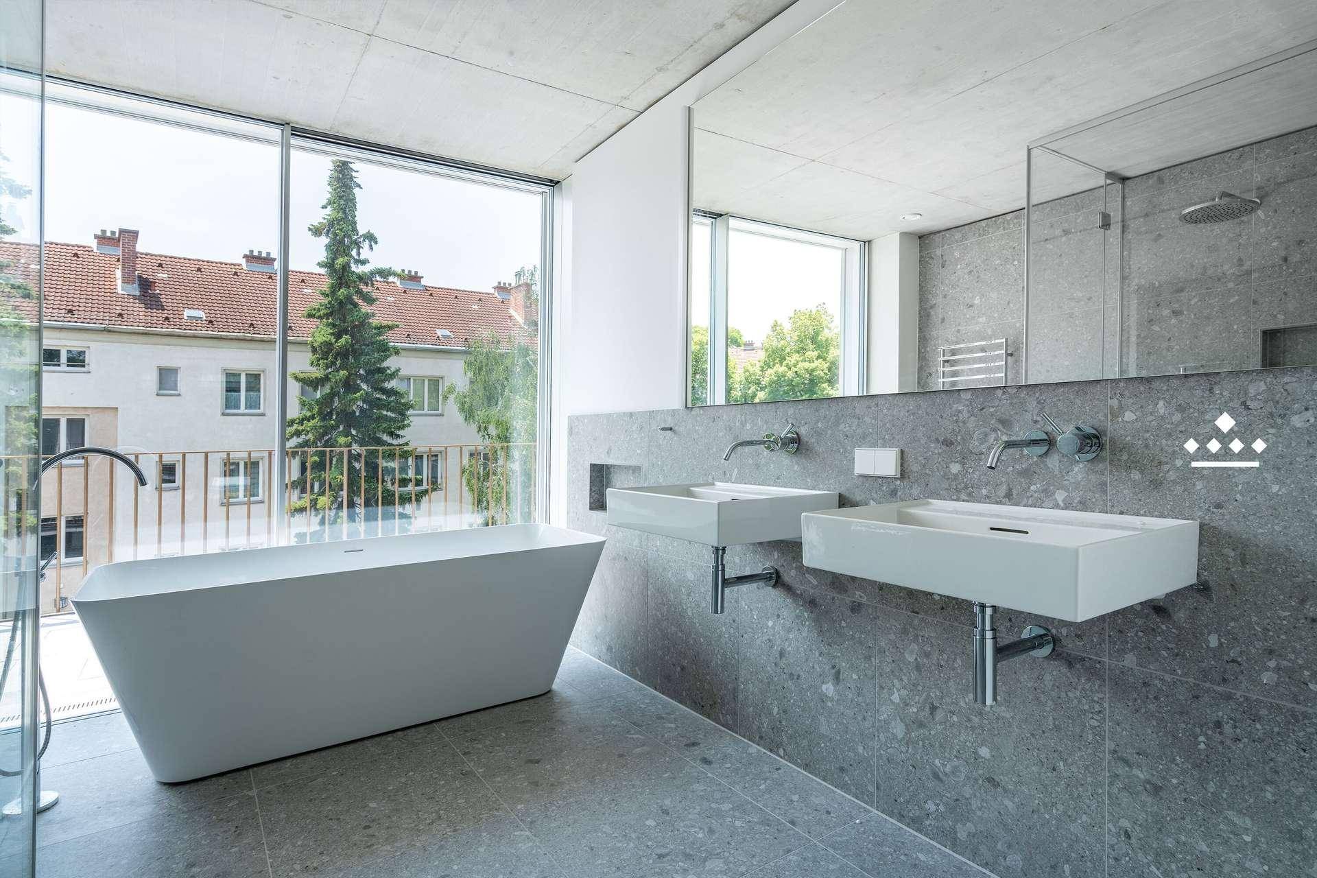 Elegantes Badezimmer mit zwei Waschbecken, freistehender Wanne und großer Dusche.