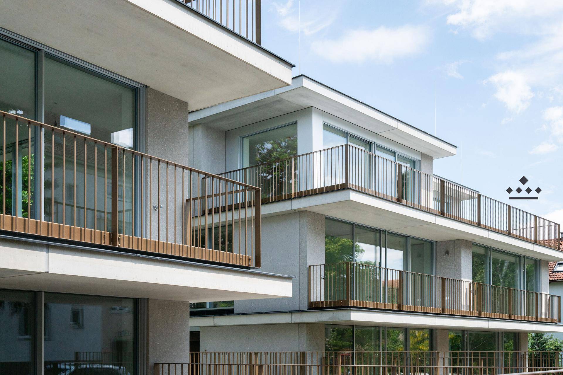 Architektur eines modernen Wohngebäudes mit gestaffelten Balkonen und großen Fenstern.