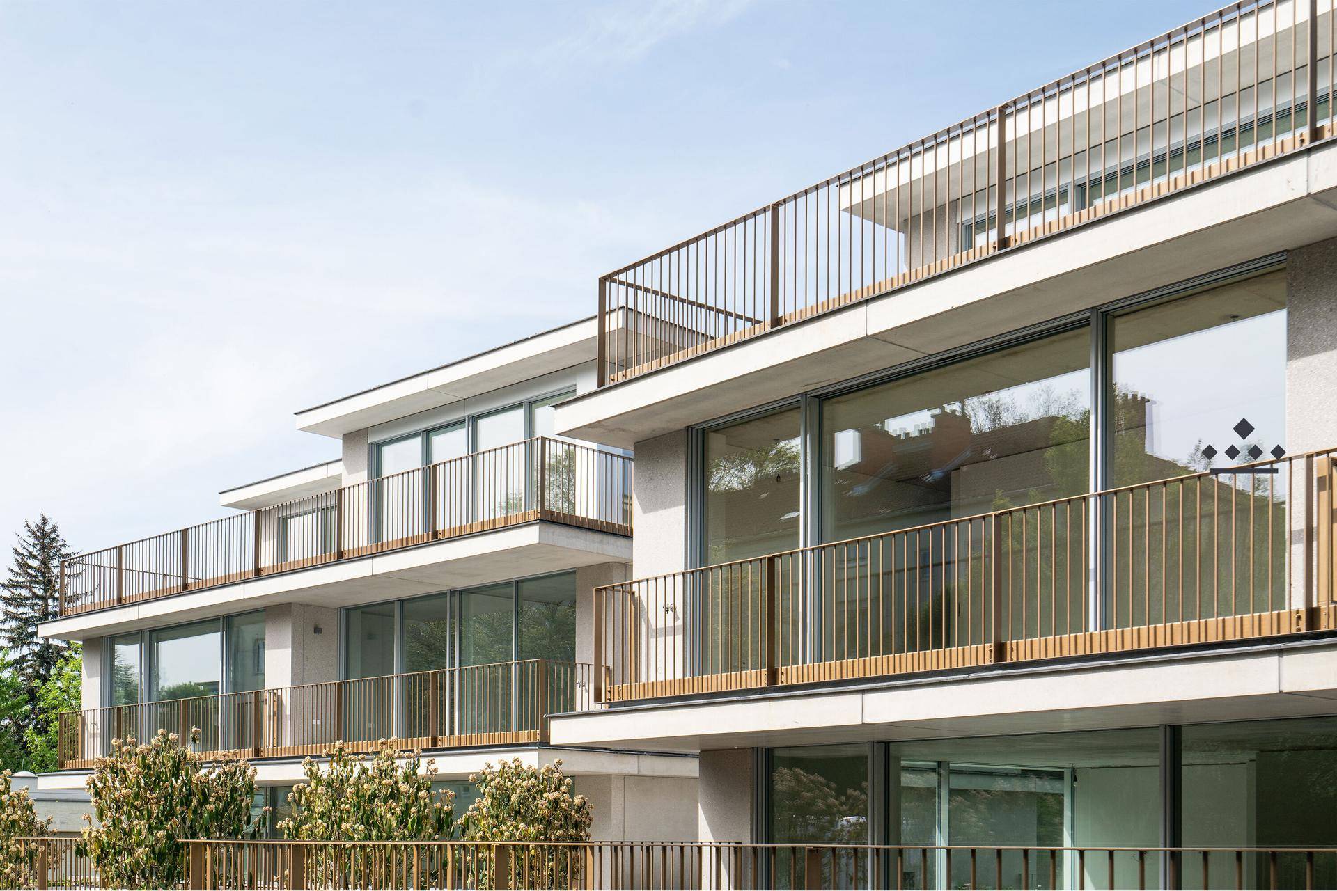 Detailansicht der modernen Fassade mit Balkonen und eleganten Geländern.