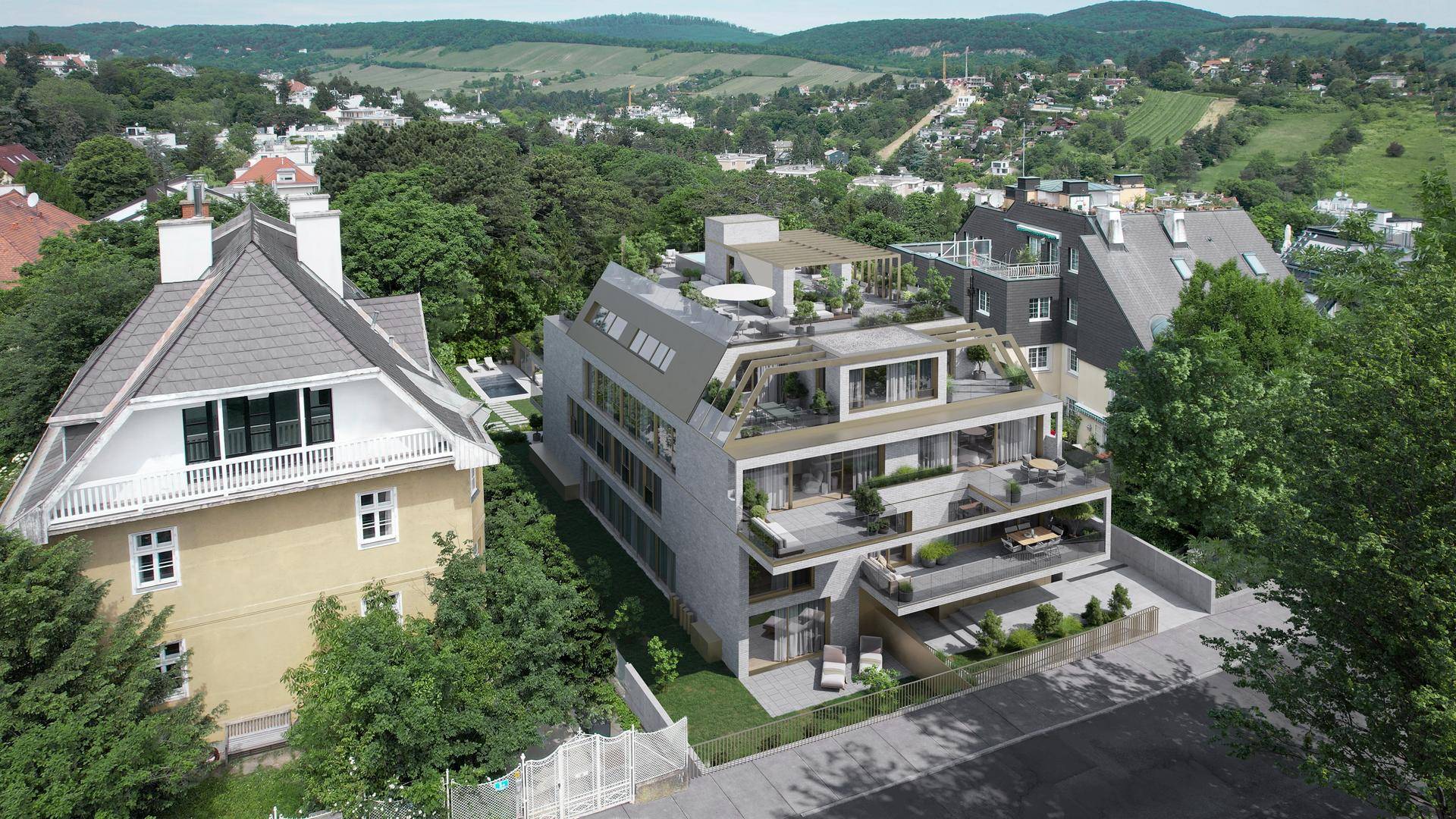 Luftaufnahme einer modernen Wohnanlage mit Terrassen und umliegender grüner Landschaft.