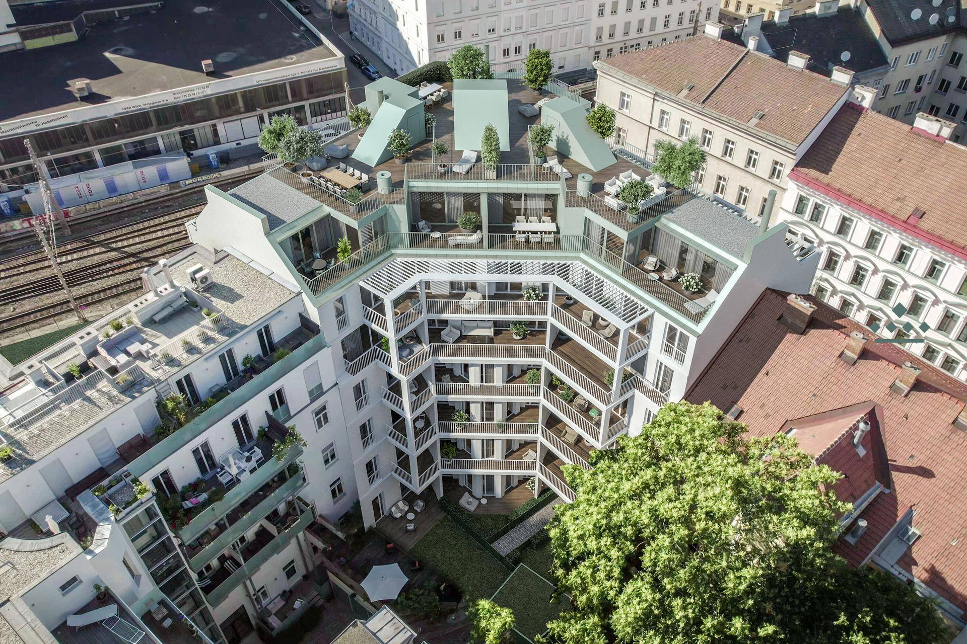 Draufsicht auf den begrünten Innenhof und die großzügigen Dachterrassen des Gebäudes.
