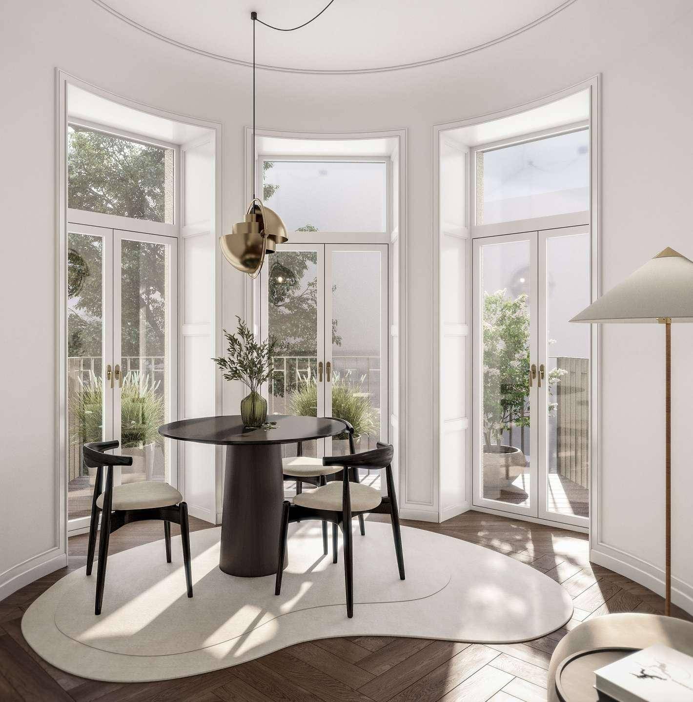 Eleganter Essbereich mit Rundtisch, Holzboden und großen Fenstern mit Balkonzugang.