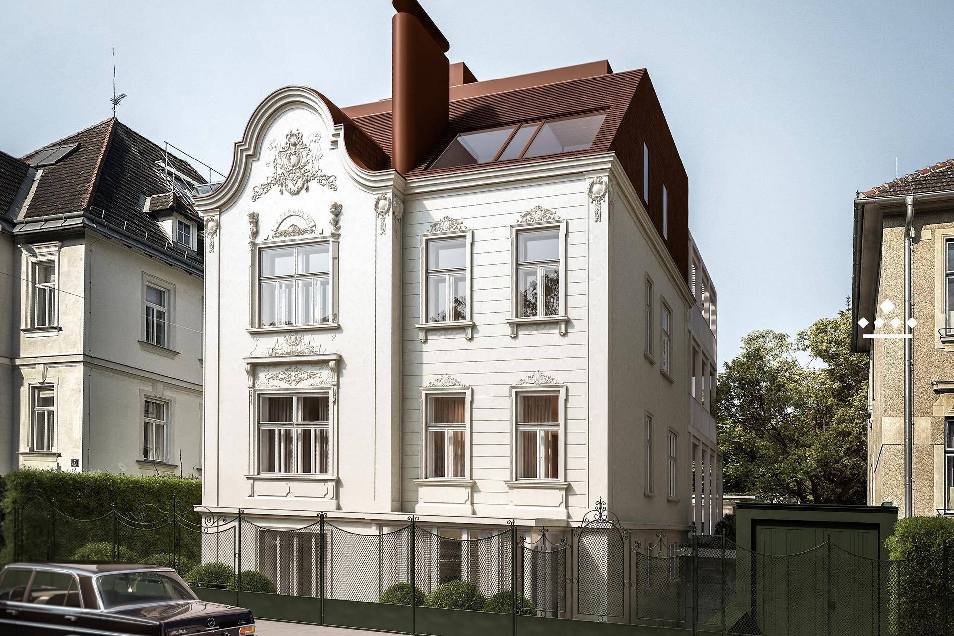 Historische Fassade eines Altbaus mit aufwendigen Stuckverzierungen und neuem Dachausbau.