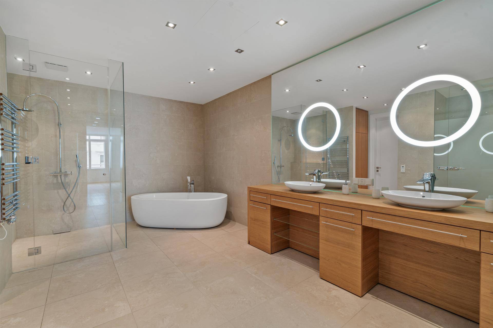 Luxuriöses Badezimmer mit freistehender Badewanne, großer begehbarer Dusche und Doppelwaschbecken.
