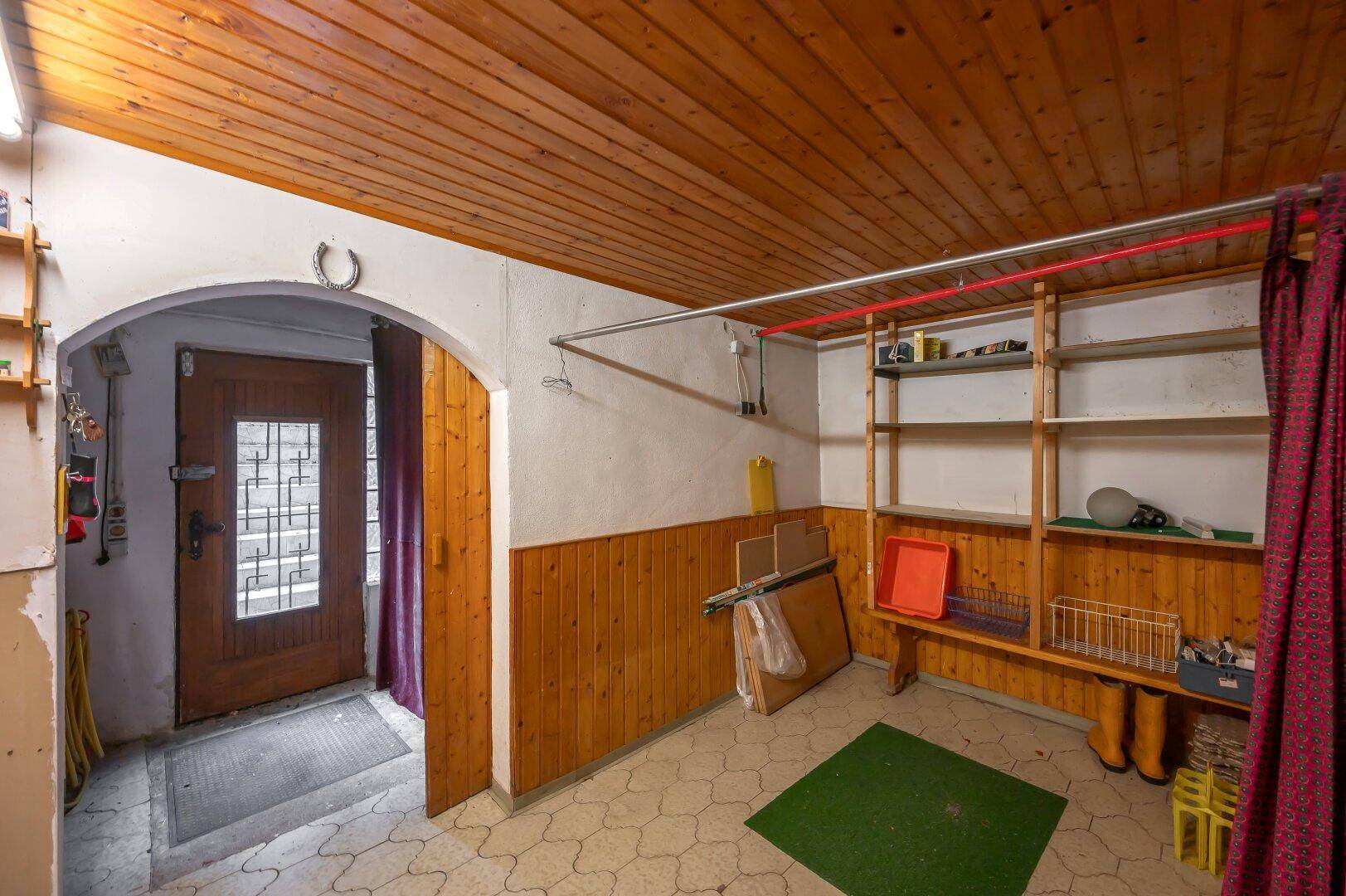 Abstellraum im Keller mit Holzvertäfelung und Regalen, bietet viel Stauraum.