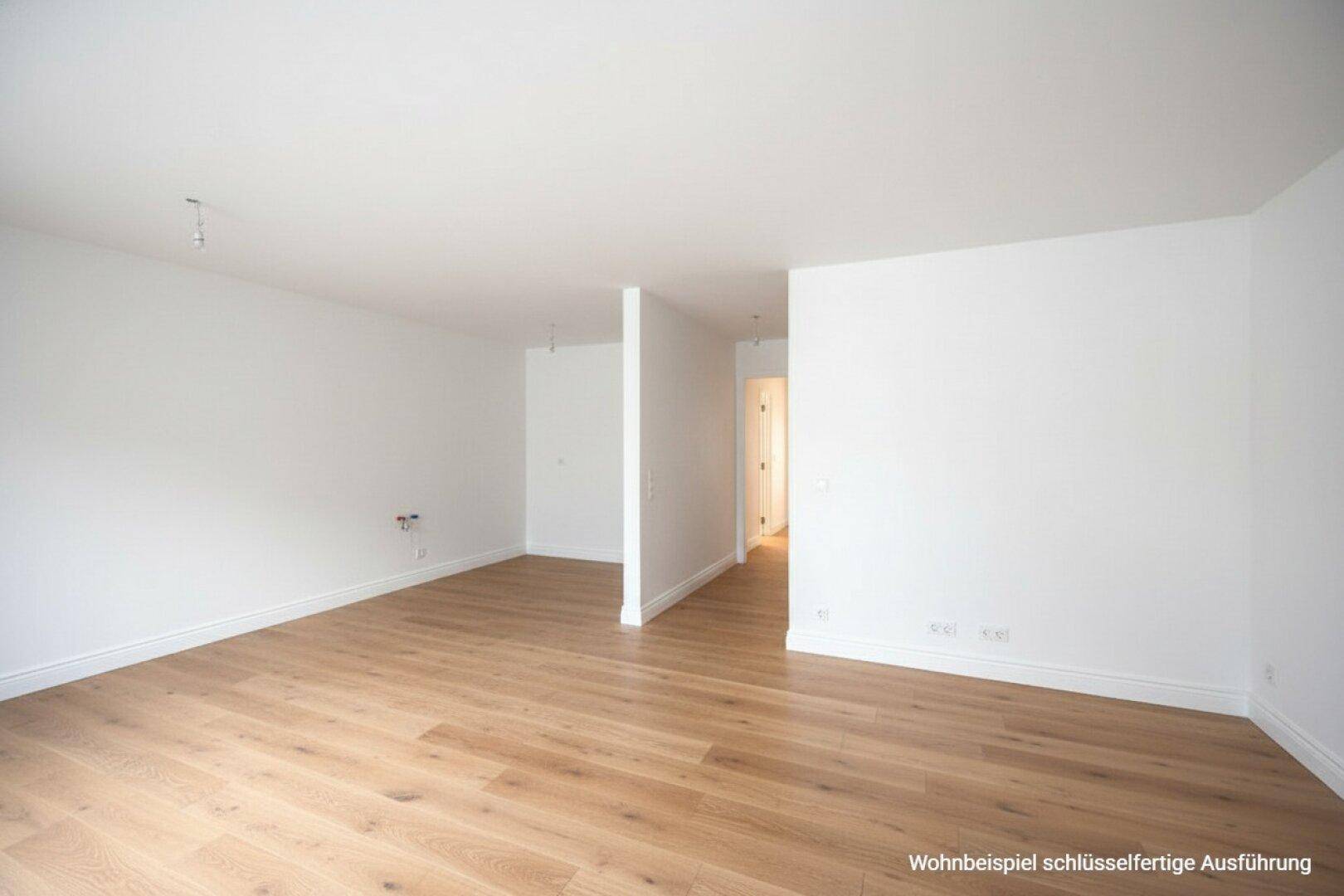 Heller Wohnraum mit weiß gestrichenen Wänden und neu verlegtem Holzboden.