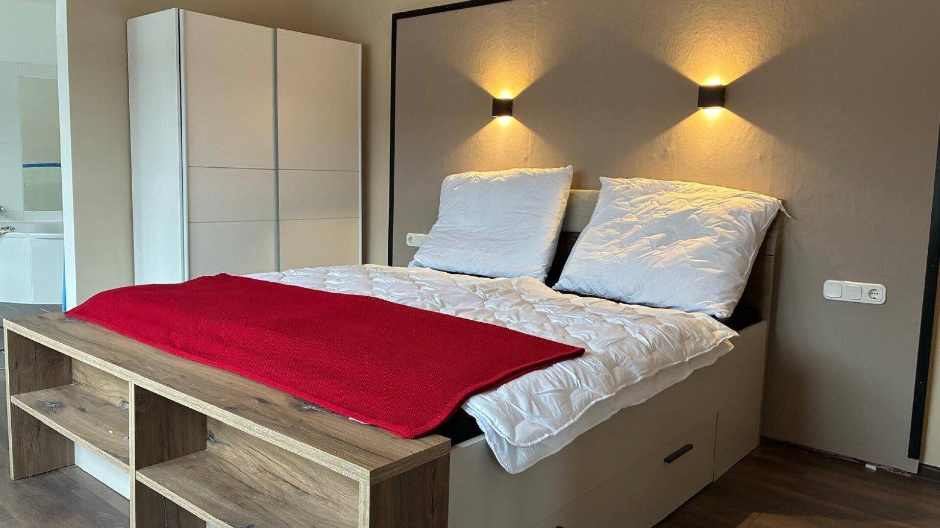 Gemütliches Schlafzimmer mit Doppelbett, integrierter Beleuchtung und modernem Kleiderschrank.