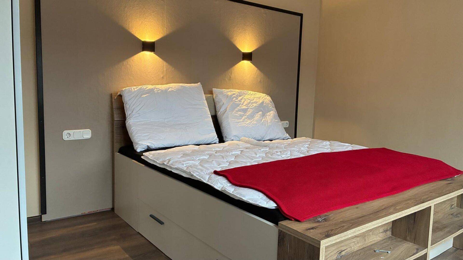 Gemütliches Schlafzimmer mit Doppelbett, integrierter Beleuchtung und modernem Kleiderschrank.